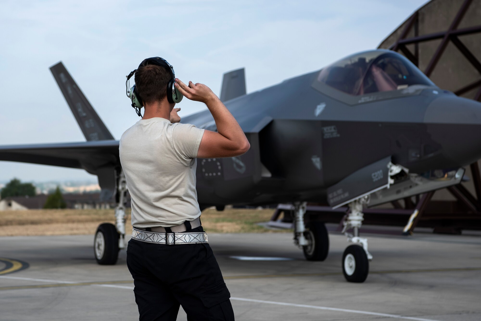 U.S. Air Force Airman 1st Class Cody Albert, 421st Fighter Squadron crew chief, marshals an F-35A Lightning II during Operation Rapid Forge at Spangdahlem Air Base, Germany, July 18, 2019. Rapid Forge aircraft are forward deploying to the territory of NATO allies to improve interoperability. The goal of the operation is to increase the readiness and responsiveness of U.S. forces in Europe and assist allies to increase regional security. (U.S. Air Force photo by Airman 1st Class Valerie Seelye)