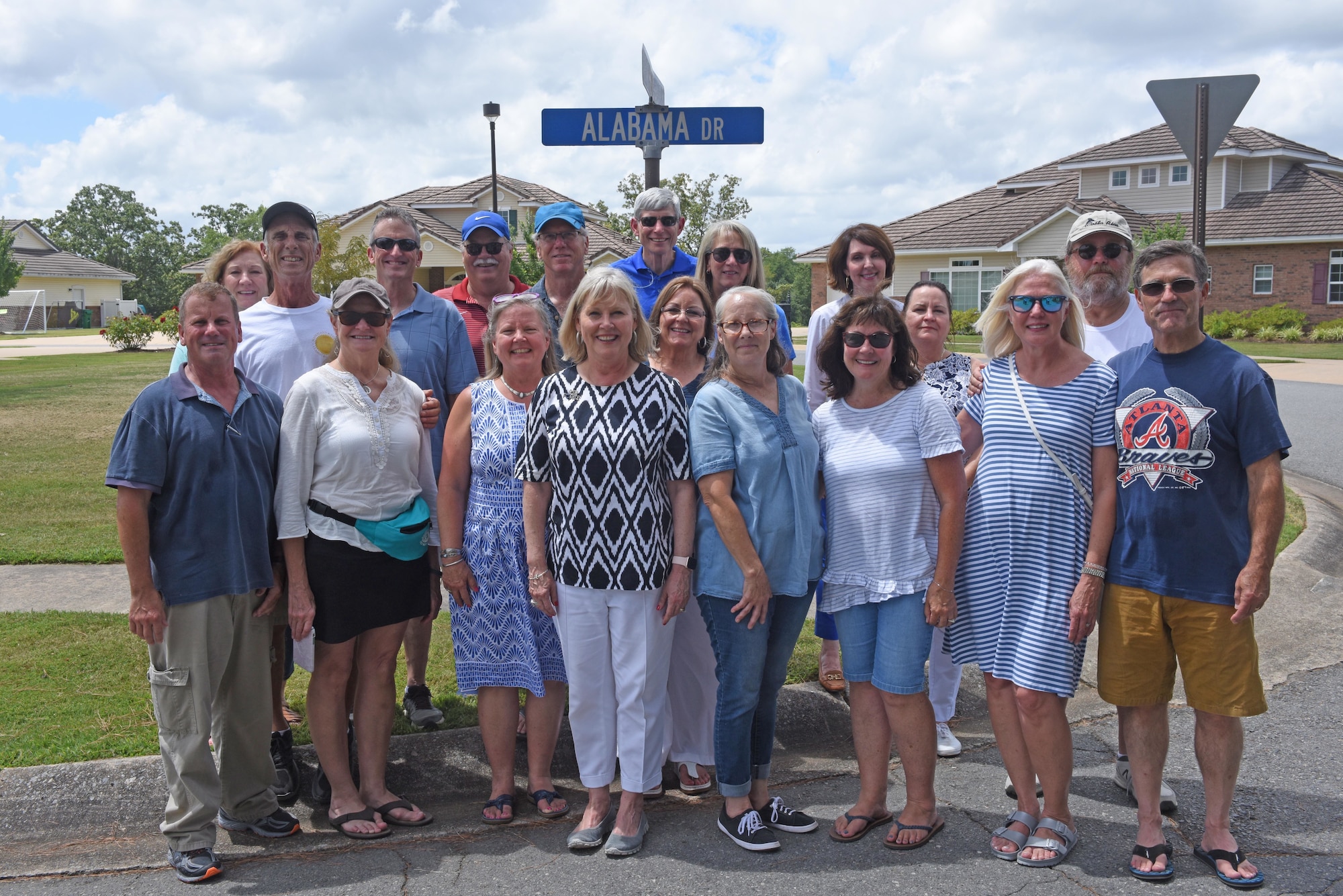 A group of friends stand in front of a street sign