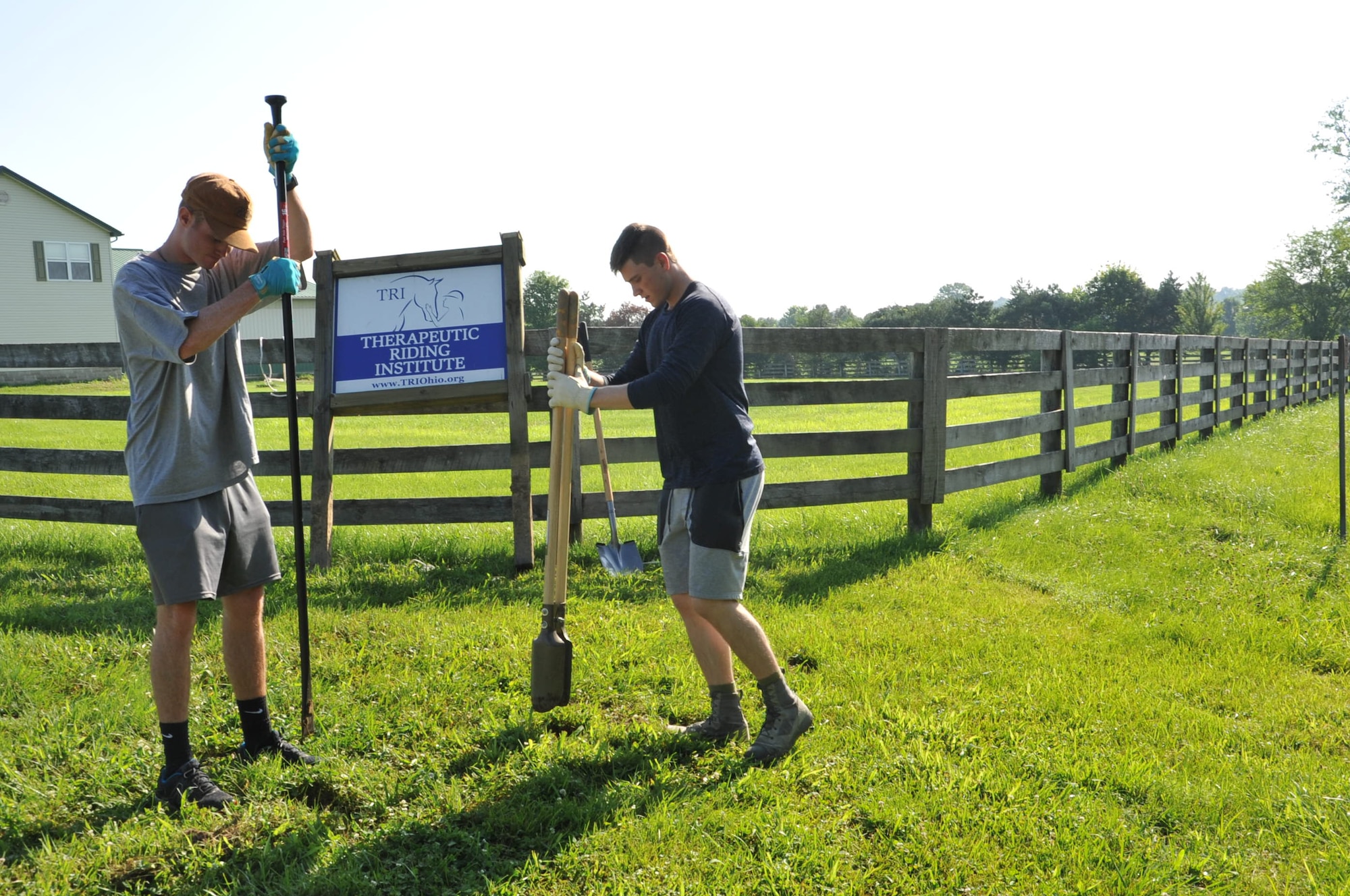 Air Force Academy Cadets Zack LaRocque, left, and Evan Place, right, dig post holes to place a sign at the Therapeutic Riding Institute. After a quality time with shovels, the duo were able to permanently place the Institute’s sign at the property’s entrance. LaRocque, Place and 18 fellow cadets travelled to Spring Valley, Ohio July 6, to volunteer with the institute ready its new location to begin operations. (U.S. Air Force photo/John Van Winkle)