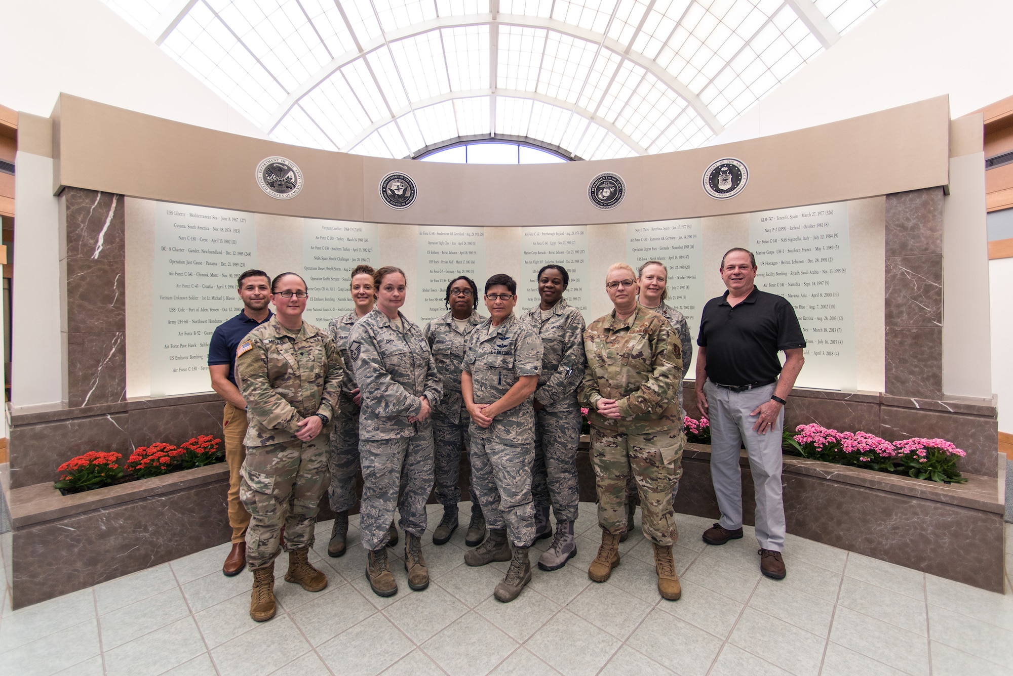 Members of the Delaware Air National Guard 166th Airlift Wing and Delaware Army National Guard pose in front of the memorial wall in the lobby of the Dover Air Force Base Mortuary Affairs Operations Center June 27, 2019. Delaware National Guard members were invited to tour Air Force Mortuary Affairs Operations and Air Forces Medical Examiner System laboratories. (U.S. Air National Guard photo by Staff Sgt. Katherine Miller)