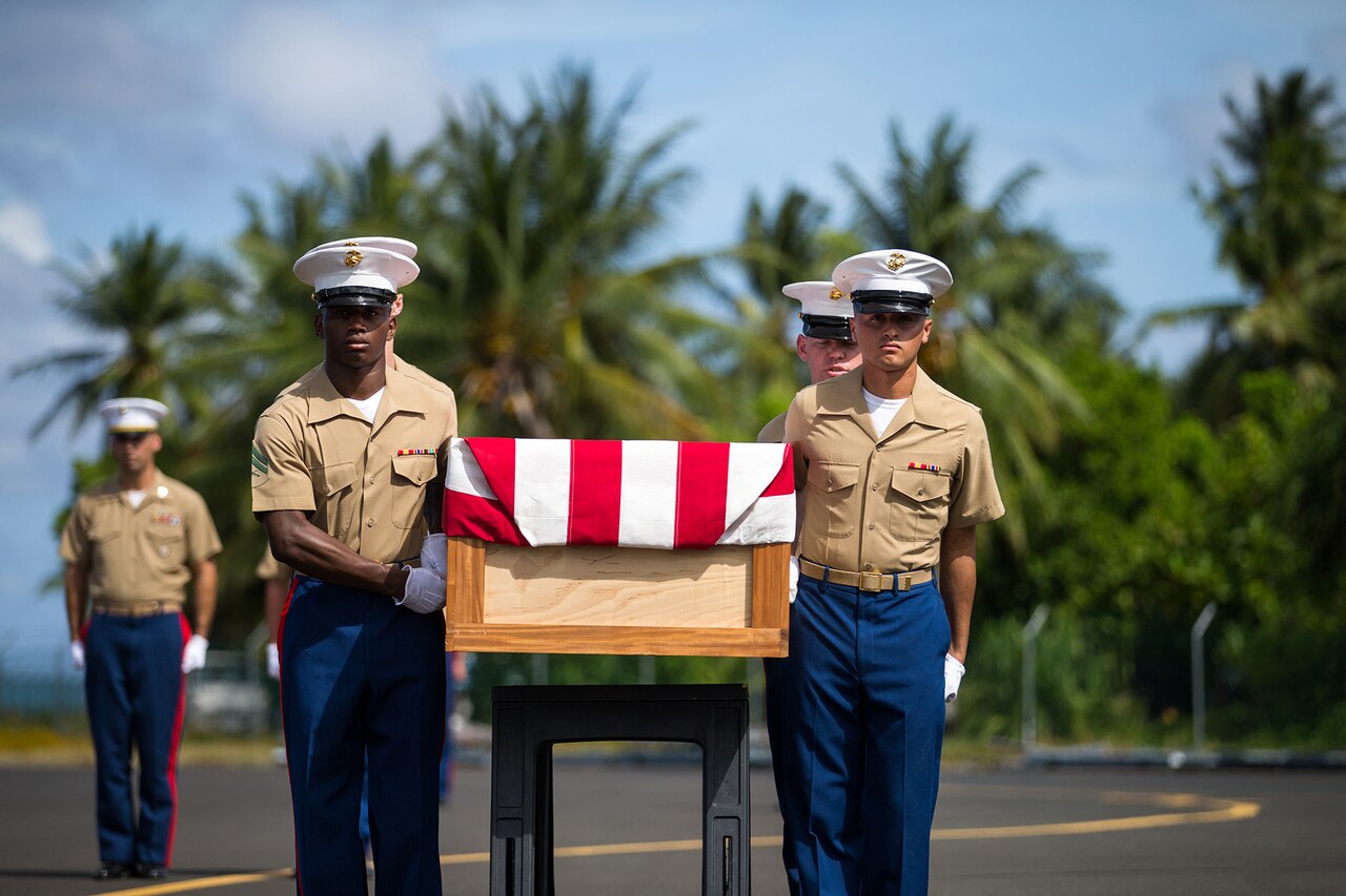 Marines carry casket.