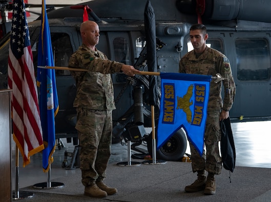 Chief Master Sgt. Jason A. Breitmaier, superintendent 855th Aircraft Maintenance Squadron (AMXS) and Maj. Jonathan J. St Peter, commander 855th AMXS, unveil the 855th AMXS guidon at a redesignation ceremony at Nellis Air Force Base, Nev., Jul. 11, 2019. The 855th AMXS maintains and repairs HH-60G Pave Hawk rescue helicopters here at Nellis. (U.S. Air Force photo by Airman 1st Class Dwane R. Young)