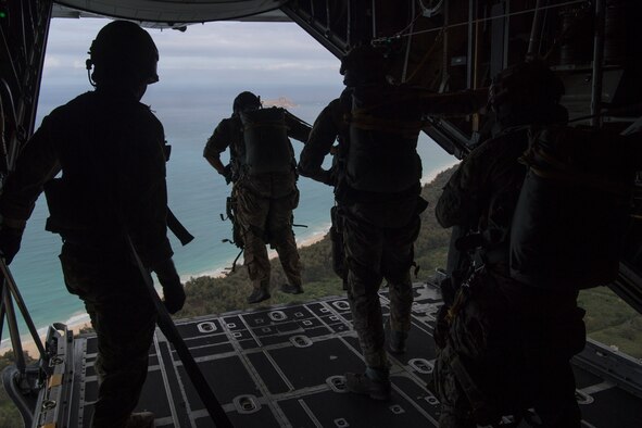 U.S. Air Force Special Tactics Airmen assigned to the 22nd Special Tactics Squadron, Joint Base Lewis-McChord, Washington, exit a C-130H Hercules aircraft during static line jump training at a range on Marine Corps Base Hawaii, June 24, 2019. Special Tactics Airmen train to land safely in a planned drop zone and conduct their mission, whether it be personnel recovery, airfield reconnaissance and establishment or special operations air integration. (U.S. Air Force photo by Staff Sgt. Rose Gudex)