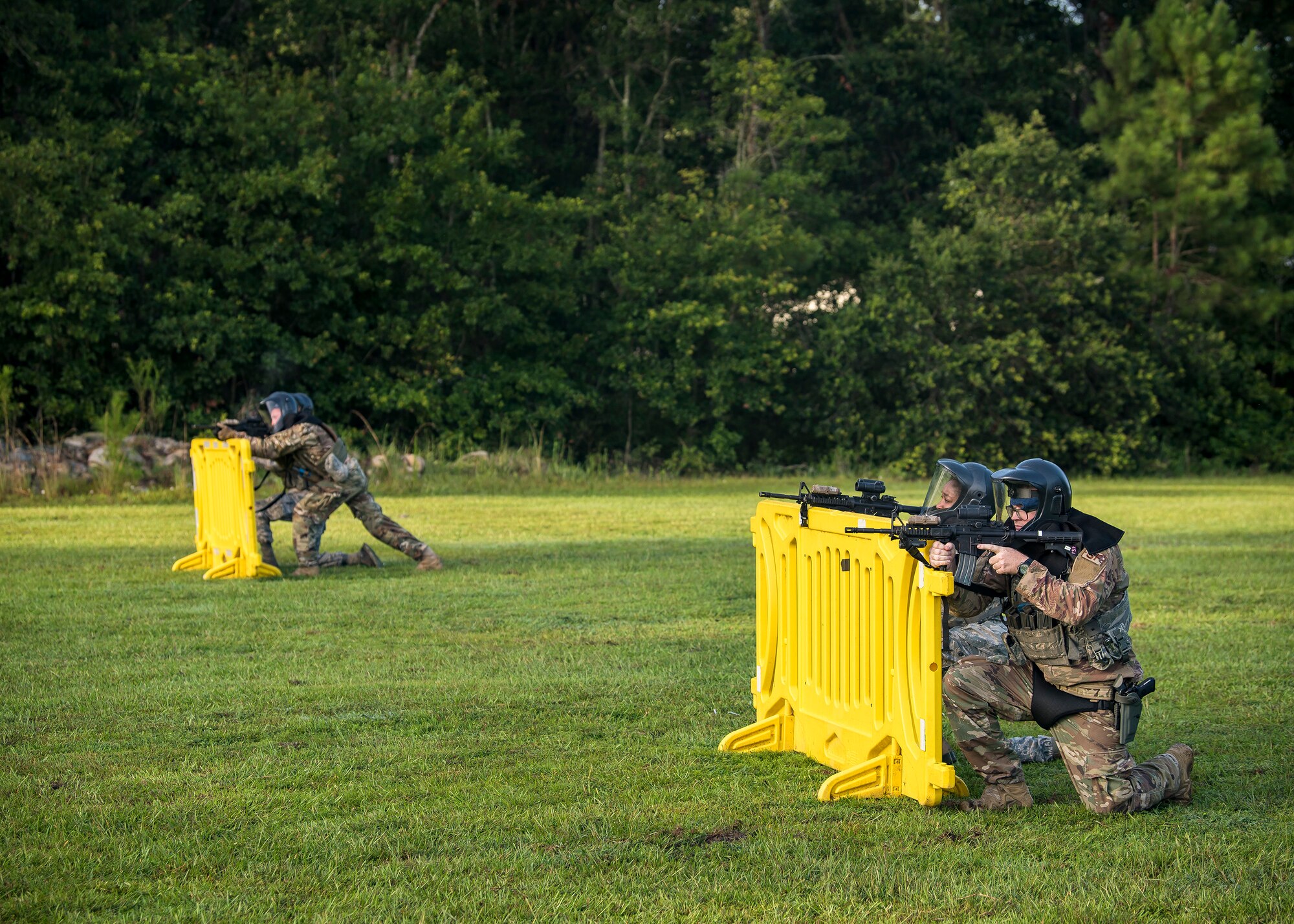Airmen from the 23d Security Forces Squadron (SFS), defend their positions during a training exercise, July 15, 2019, at Moody Air Force Base, Ga. The “Shoot, move, communicate” training exercise put participants through practice maneuvers taking turns providing cover fire while others advanced on the enemy. Airmen learned how to shoot, move and communicate to build confidence in themselves, their wingmen and with their weapons. (U.S. Air Force photo by Airman 1st Class Eugene Oliver)