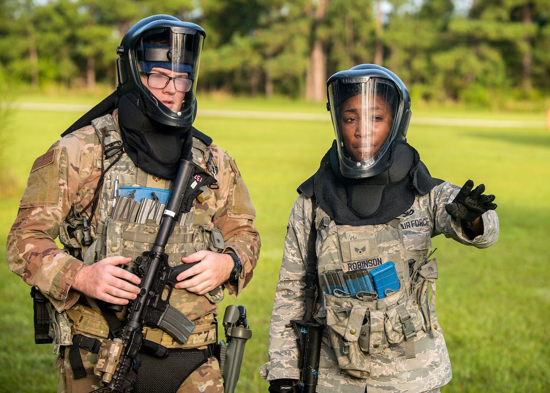 Senior Airman Marcuria Robinson, and Senior Airman Micah McCall, both 23d Security Forces Squadron patrolmen, discuss strategy prior to a training exercise, July 15, 2019, at Moody Air Force Base, Ga. The “Shoot, move, communicate” training exercise put participants through practice maneuvers taking turns providing cover fire while others advanced on the enemy. Airmen learned how to shoot, move and communicate to build confidence in themselves, their wingmen and with their weapons. (U.S. Air Force photo by Airman 1st Class Eugene Oliver)