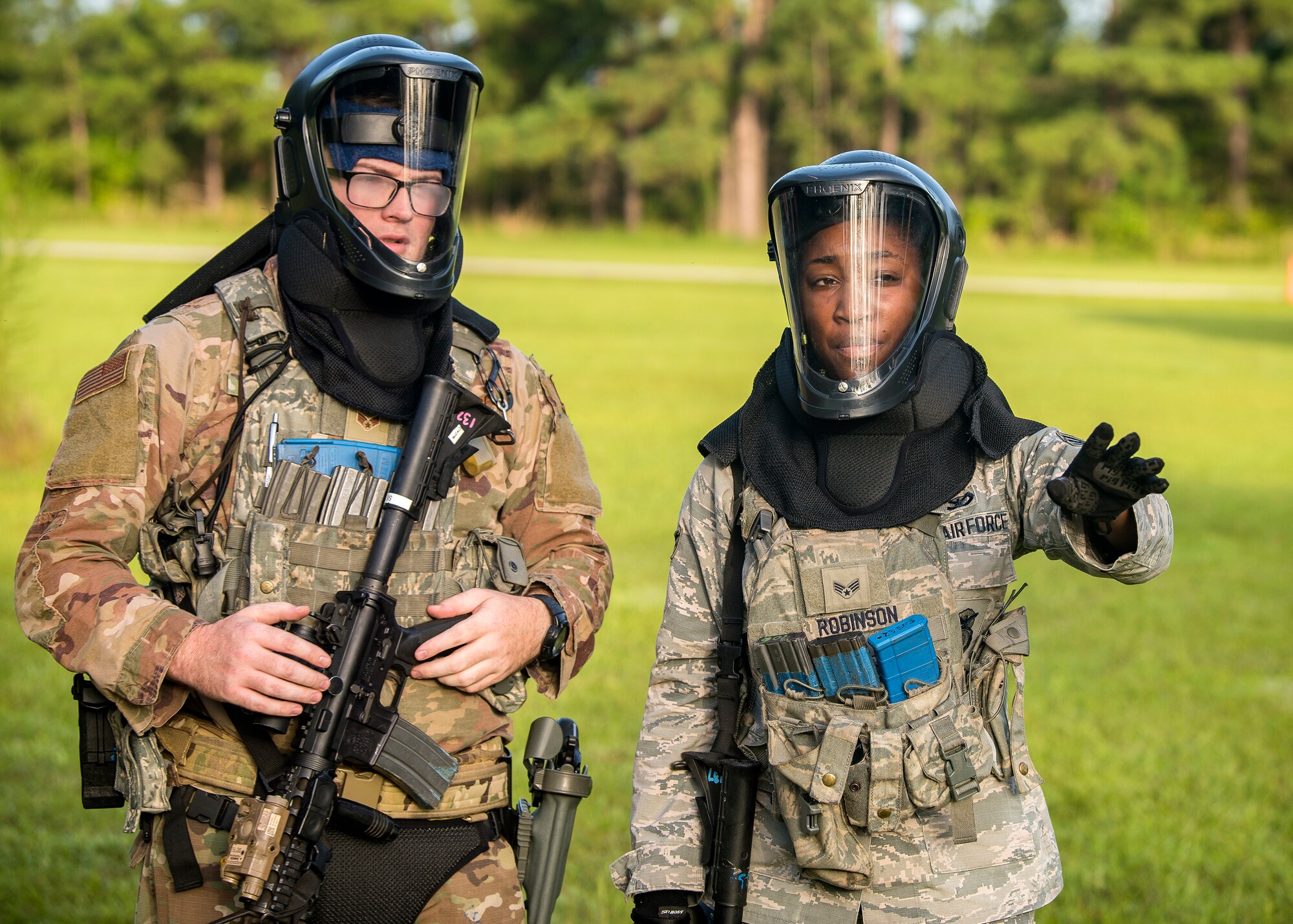 Senior Airman Marcuria Robinson, and Senior Airman Micah McCall, both 23d Security Forces Squadron patrolmen, discuss strategy prior to a training exercise, July 15, 2019, at Moody Air Force Base, Ga. The “Shoot, move, communicate” training exercise put participants through practice maneuvers taking turns providing cover fire while others advanced on the enemy. Airmen learned how to shoot, move and communicate to build confidence in themselves, their wingmen and with their weapons. (U.S. Air Force photo by Airman 1st Class Eugene Oliver)