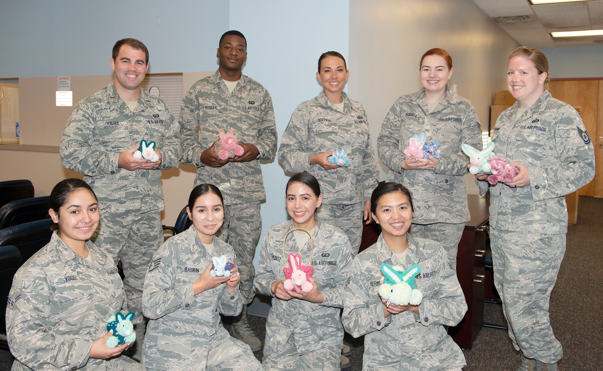 Members of 55th Comptroller Squadron Financial Management flight pose with crocheted rabbits made by Sally Harder July 1, 2019, at Offutt Air Force Base, Nebraska. Harder, a retired military spouse and grandmother to Airman 1st Class Julie Hubble, financial services technician enjoys crafting for others.  “I’ve been making things for people all of my life it’s just little things to brighten up their desk,” said Harder.