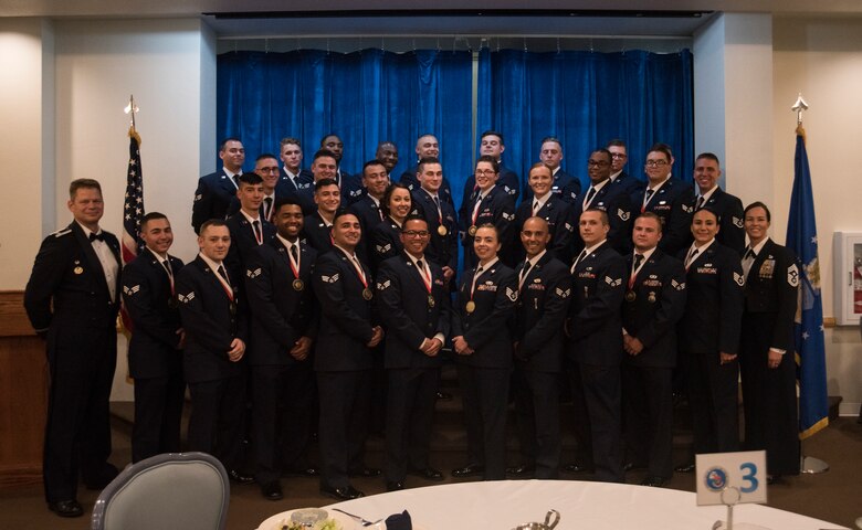 Col. Peter Bonetti, 90th Missile Wing commander, and Chief Master Sgt. Tiffany Bettisworth, 90th MW command chief, pose for a photo with Airman Leadership School class 19-F July 17, 2019, on F.E. Warren Air Force Base, Wyo. ALS is a six-week course designed to prepare Airmen to assume supervisory duties as well as instruction in the practice of leadership and followership. Enlisted Airmen must graduate ALS before supervising other Airmen. (U.S. Air Force photo by Senior Airman Abbigayle Williams)