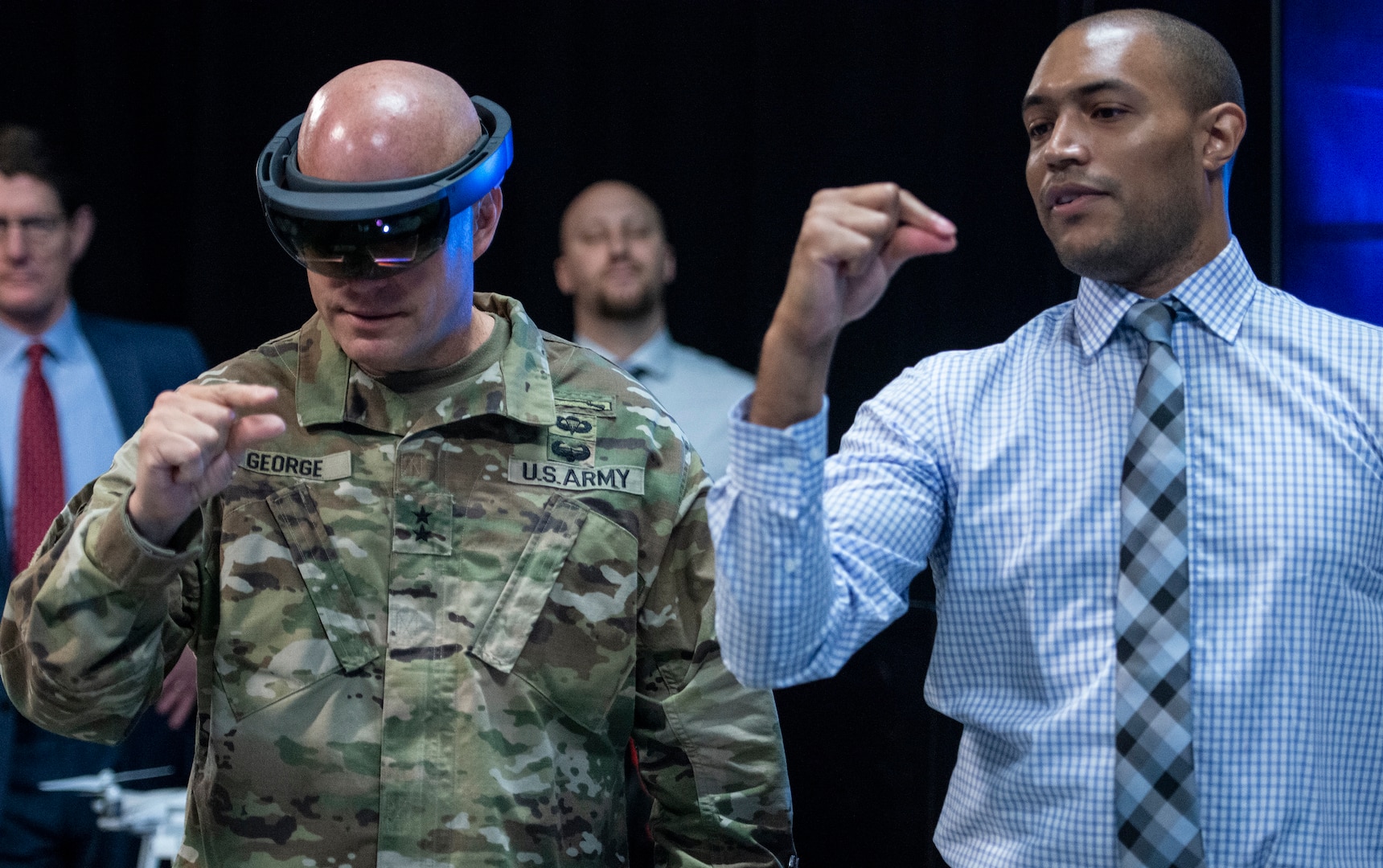 Austin Drexler, researcher at the Institute for Creative Technology in Los Angeles, helps Maj. Gen. John George use special interactive goggles to view One World Terrain 3D interactive simulation data. George is deputy director, Army Futures and Concepts Center.