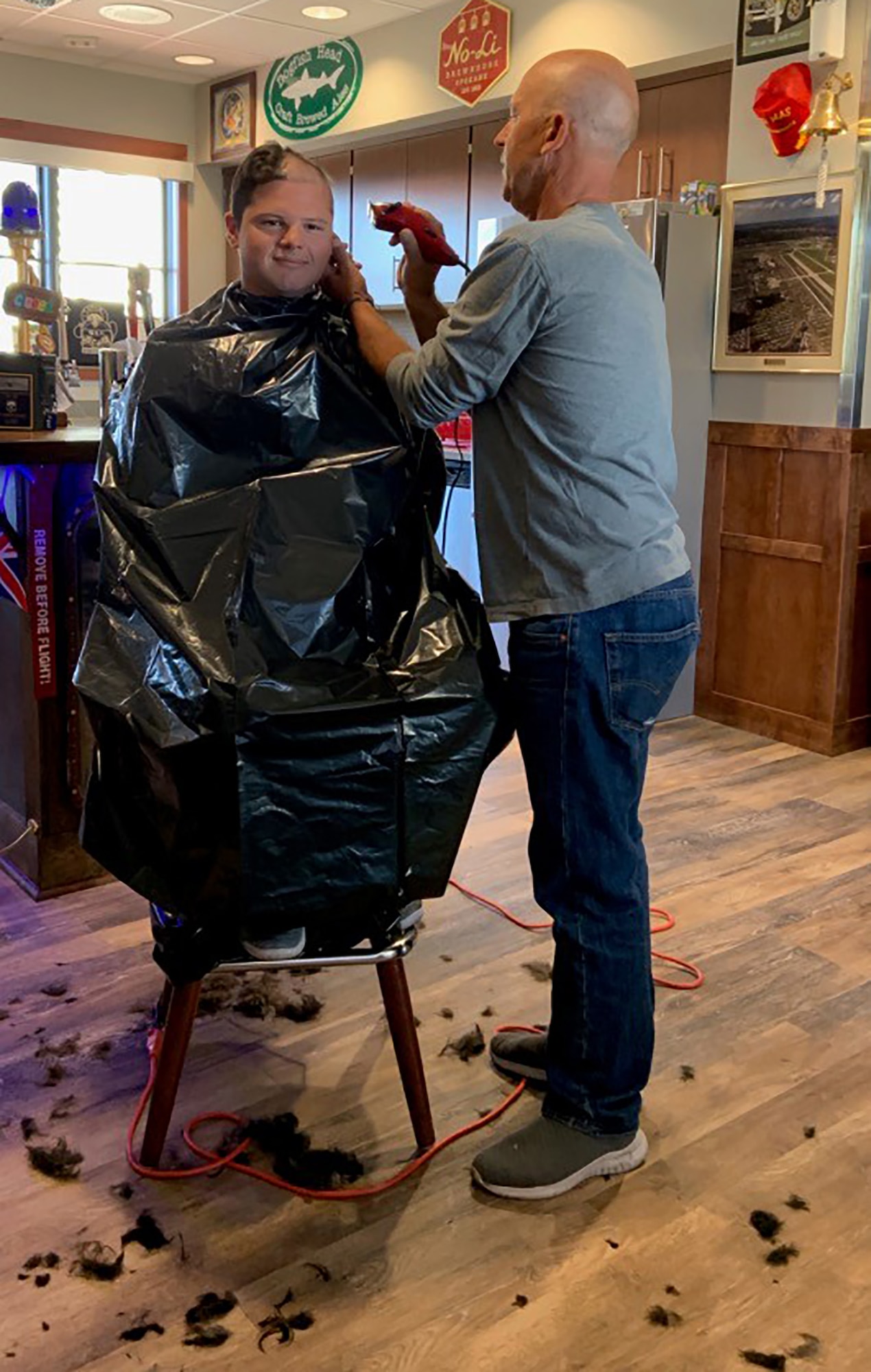 Without hesitation, 312th Airlift Squadron teammates transformed their heritage room into a makeshift barbershop and administered basic training style shearing in support of Master Sgt. Steve Hatfield.