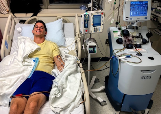 Maj. Matt Tucker, 33rd Fighter Wing F-35A pilot, smiles during his a peripheral blood stem cell (PBSC) donation at Georgetown University Hospital, Washington D.C., on July 8th, 2019. For the PBSC donation, a needle is placed in one arm to extract blood which is run through a machine that separates the different components. Stem cells and platelets are stored while red and white blood cells are returned to the donor.