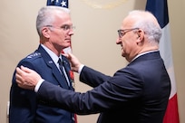Civilian presents award to airman.