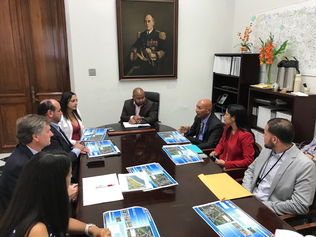 Six people seating around a conference room table