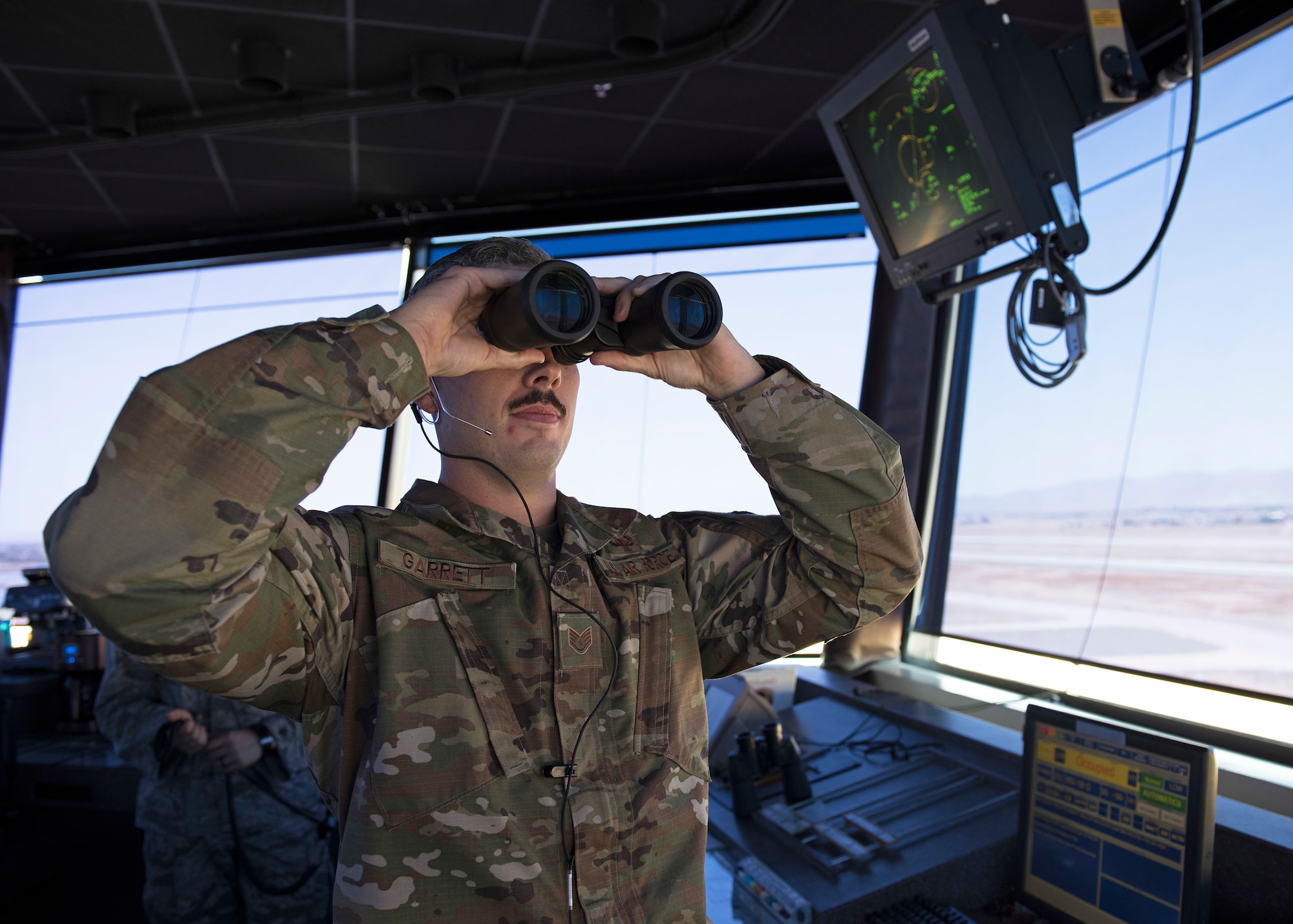 Staff Sgt. George Garrett, 56th Operation Support Squadron air traffic controller, scans the horizon for a pair of F-35 Lightning II aircraft returning from a mission from the Air Traffic Control Tower July 15, 2019, at Luke Air Force Base, Ariz.