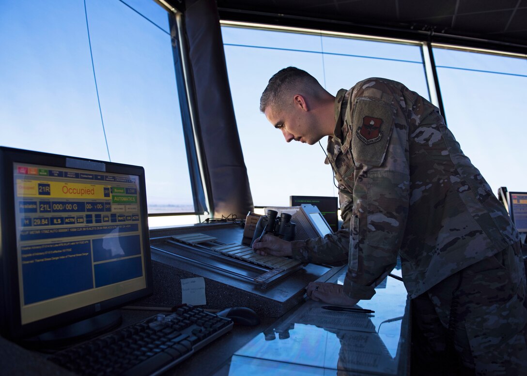 Staff Sgt. George Garrett, 56th Operation Support Squadron air traffic controller, writes down information on a flight progress strip in the Air Traffic Control Tower July 15, 2019, at Luke Air Force Base, Ariz.