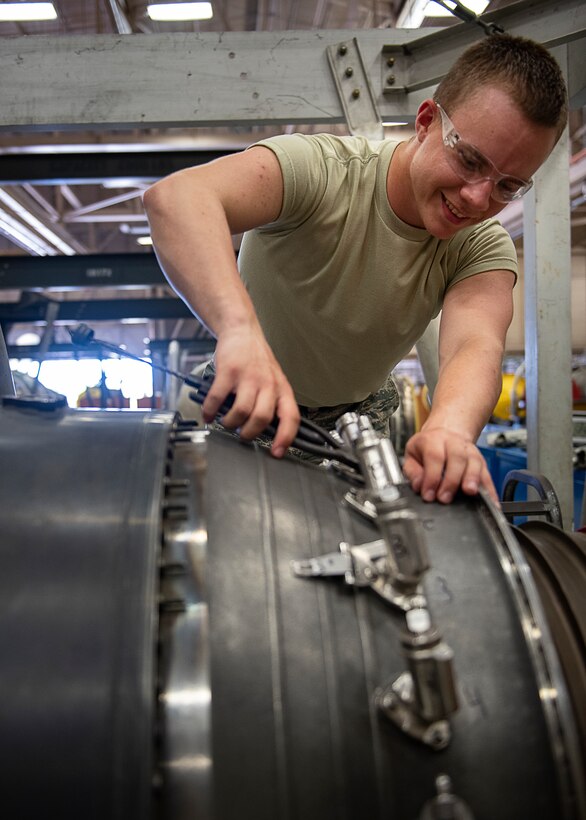 Airman 1st Class Jeremiah Butler, 361st Training Squadron aerospace propulsion apprentice course student, removes safety wires from a F110 turbine engine at Sheppard Air Force Base, Texas, July 18, 2019. Butler is a native of St. Louis, Missouri and is attending technical training school at Sheppard AFB. In this block of training he is learning to remove and re-install the fuel nozzle section of the engine. The students complete these tasks over and over as it helps them understand the engine as well as teaches them to identify faults and discrepancies during an inspection. (U.S. Air Force photo by Airman 1st Class Pedro Tenorio)