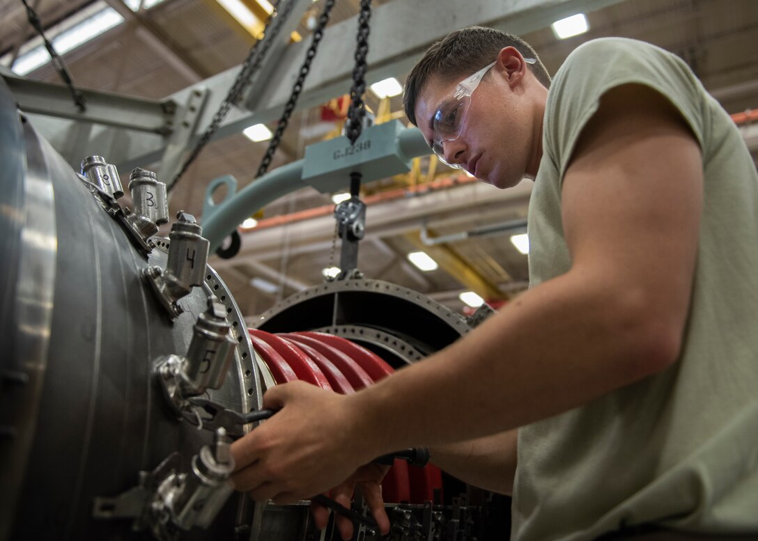 Airman Alex Volpe, 361st Training Squadron aerospace propulsion apprentice course student, removes safety wires from a F110 turbine engine at Sheppard Air Force Base, Texas, July 18, 2019. Volpe is a native to Canton, Ohio, and is attending technical training at Sheppard AFB. In this block of training he is learning how to remove and re-install the fuel nozzle section of the engine. The first step to removing it, is removing the safety wires which is used to secure most parts on the engine. (U.S. Air Force photo by Airman 1st Class Pedro Tenorio)