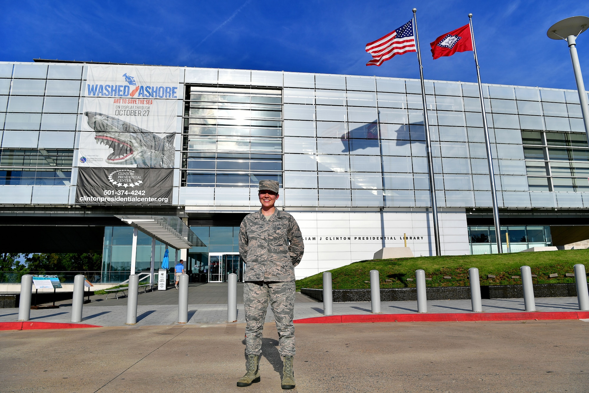 An Airman stand in front of the library she will be interlining at.