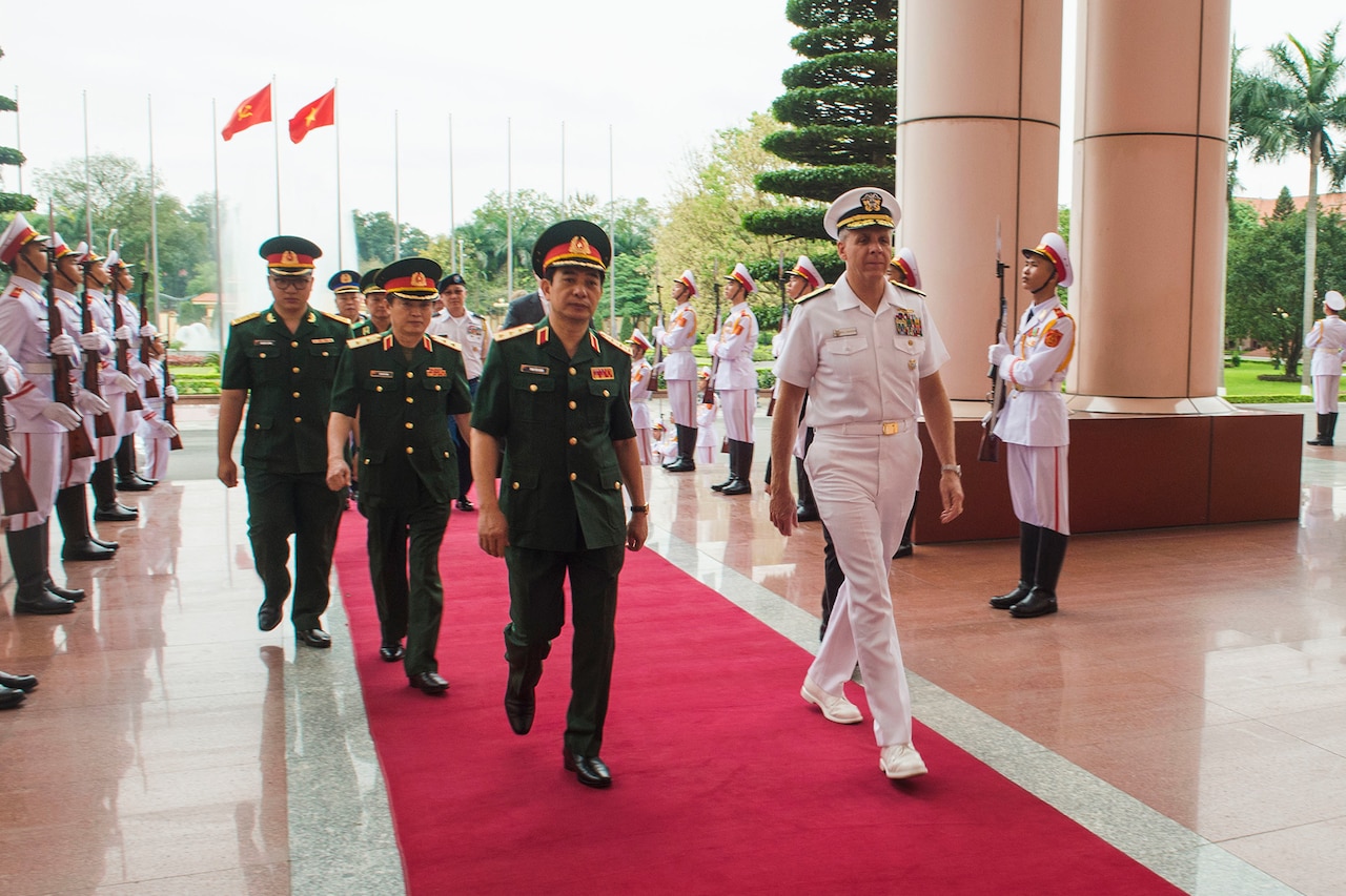 Men walk down red carpet.