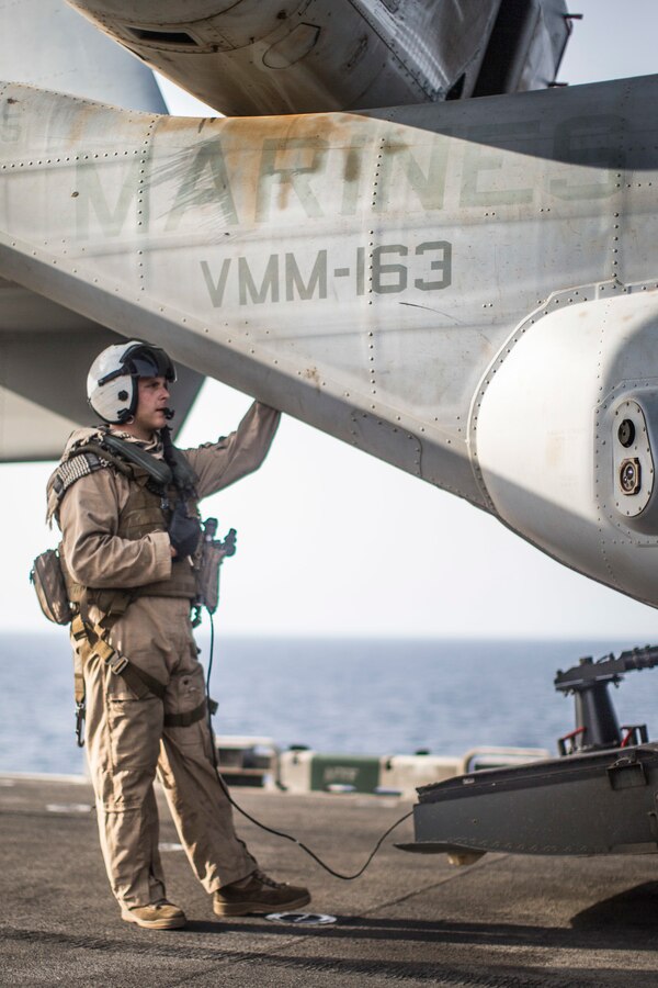 190703-M-EC058-1226 GULF OF ADEN (July 3, 2019) U.S. Marine Corps Cpl. Logan Newson, an MV-22 Osprey crew chief with Marine Medium Tiltrotor Squadron (VMM) 163 (Reinforced), 11th Marine Expeditionary Unit (MEU), stands near an MV-22 Osprey during flight operations aboard the amphibious assault ship USS Boxer (LHD 4). The Boxer Amphibious Ready Group and the 11th MEU are deployed to the U.S. 5th Fleet area of operations in support of naval operations to ensure maritime stability and security in the Central Region, connecting the Mediterranean and the Pacific through the Western Indian Ocean and three strategic choke points. (U.S. Marine Corps photo by Lance Cpl. Dalton Swanbeck)