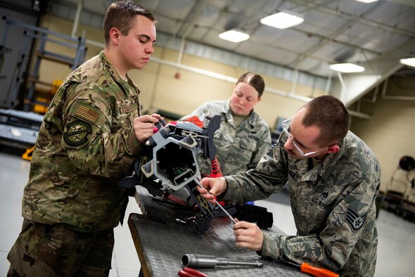 Senior Airman Sydney Starkey, left, 23d Maintenance Squadron (MXS) armament (ARMs) flight alternate mission equipment (AME) element member, Airman 1st Class Hadleigh Brabbin, center, 23d MXS ARM AME element member, and Staff Sgt. Arthur Vigil, 23d MXS ARM AME floor supervisor, remove a bracket from a triple ejector rack for maintenance, July 17, 2019, at Moody Air Force Base, Ga. The ARMs shop primarily performs quality armament systems maintenance and inspections to provide aircrews with safe and reliable weapon systems for lethal airpower employment. (U.S. Air Force photo by Senior Airman Erick Requadt)