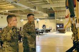 Col. Richard Bailey, 3d Medical Command Deployment Support - Forward commander, and Command Sgt. Maj. Robert Bennett salute the unit colors after they uncase them during a transfer of authority ceremony at Camp As Sayliyah, Qatar, July 18, 2019.