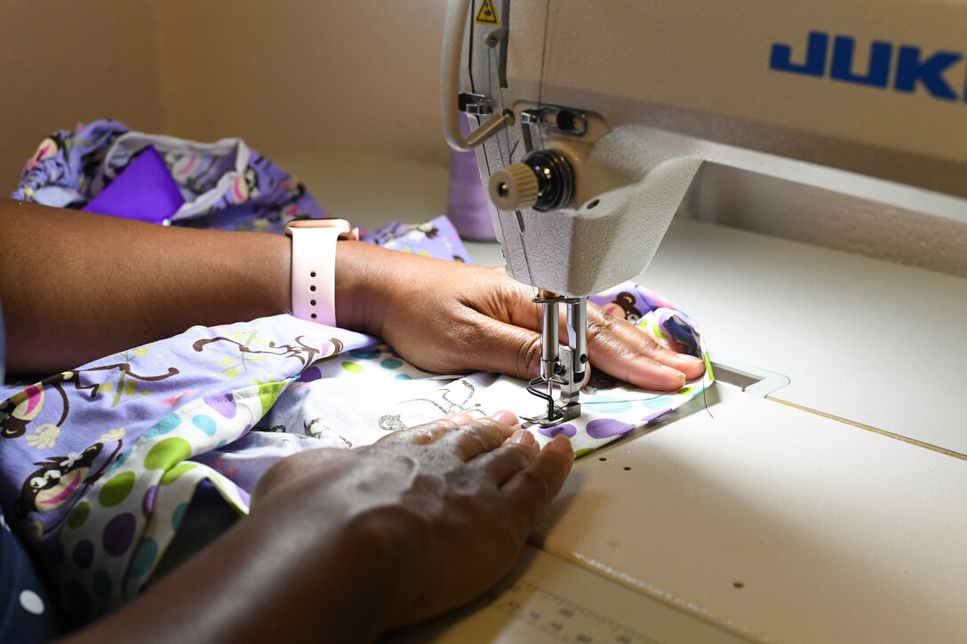 Master Sgt. (Ret.) Keena Alston, 916th Air Refueling Wing commander’s secretary, works fabric through a sewing machine on July 12, 2019. Alston makes dresses that are delivered to vulnerable children all around the world by missionary volunteers. (US Air Force Photo by Jeramy Moore)