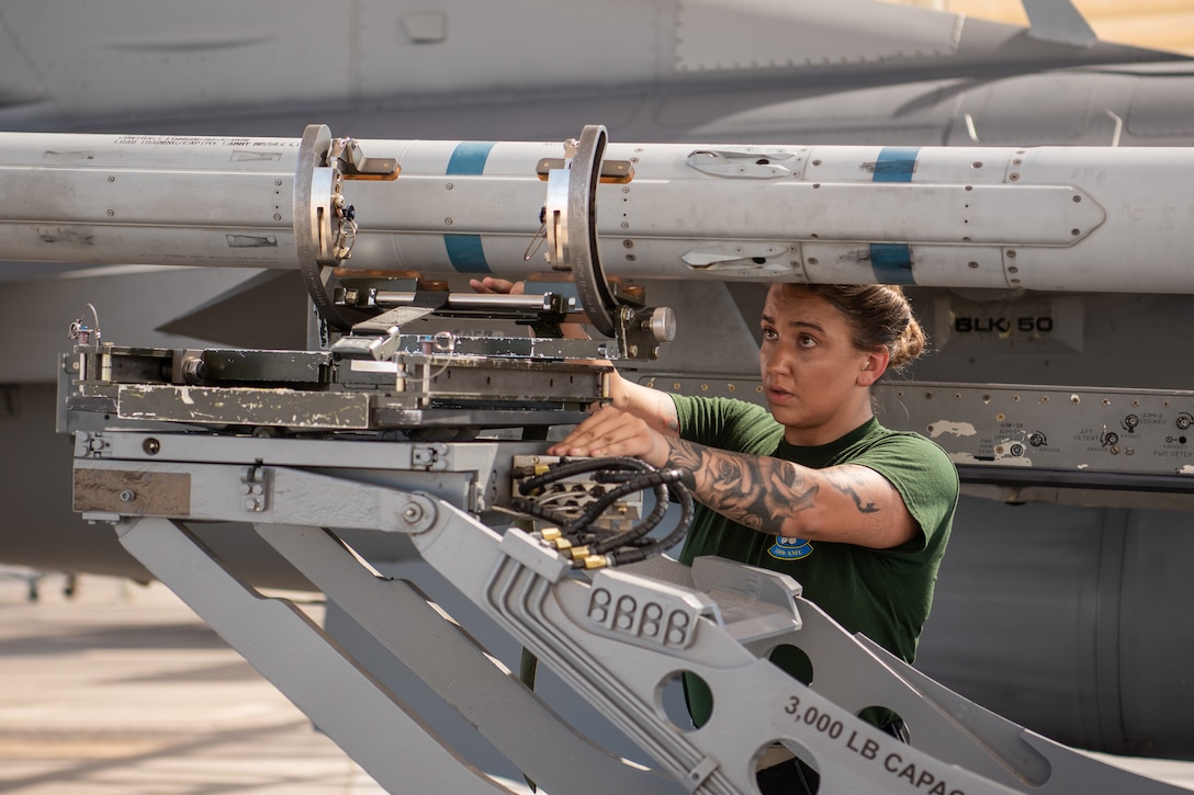 Staff Sgt. Katrina Stuhl, 310th Aircraft Maintenance Unit load crew member, loads a bomb onto an F-16 Fighting Falcon, July 18, 2019, at Luke Air Force Base, Ariz.