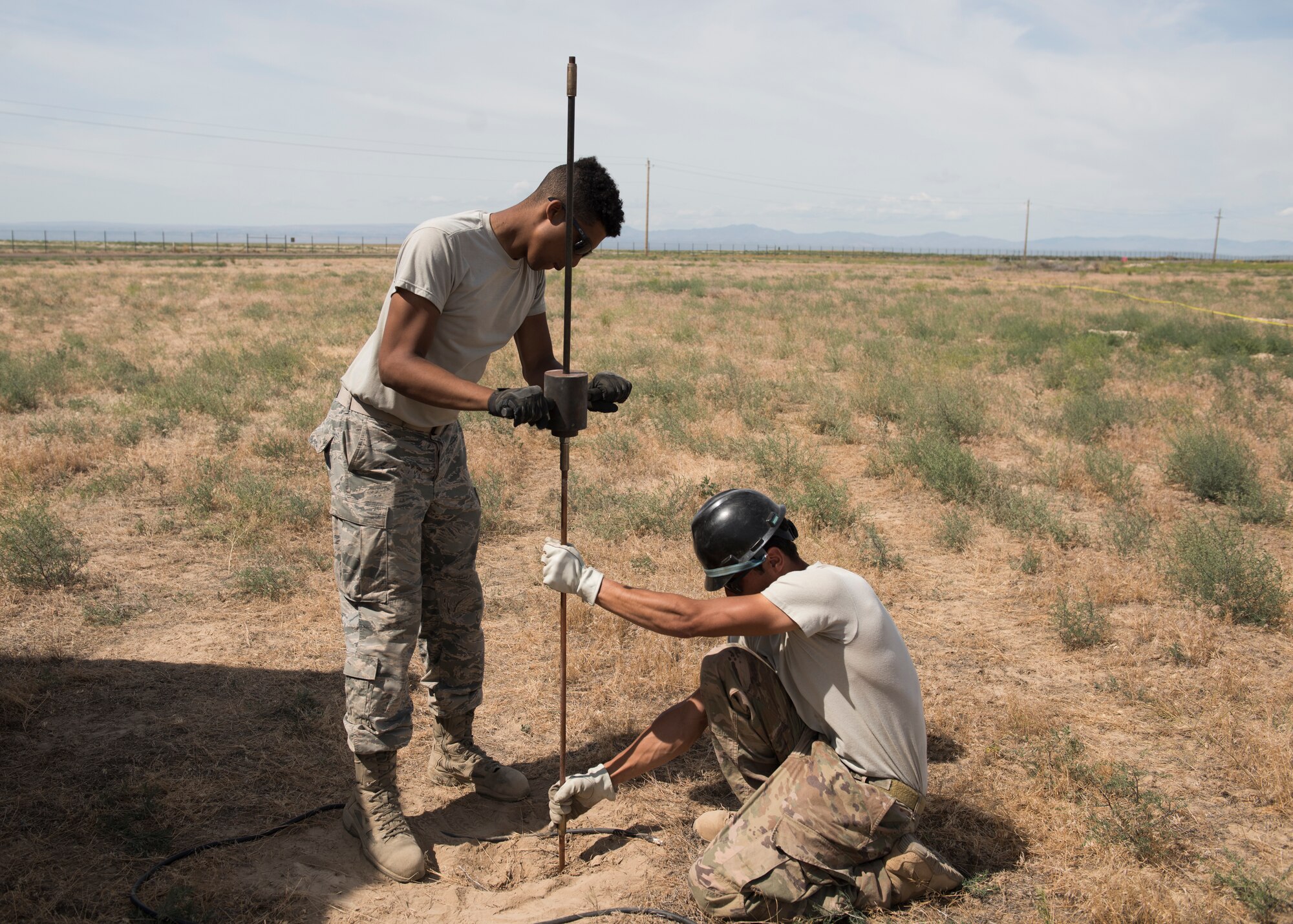 U.S Air Force Airman 1st Class Miles Swammi, 726th Air Control Squadron radar systems technician, and U.S. Air Force Airman Tech. Sgt. Jacob Jacques, 726th ACS radar systems technician, install a grounding rod during the 726th ACS Hardrock Exercise 19-2, July 16, 2019, at Mountain Home Air Force Base, Idaho. The 726th ACS plays a vital role in the communication capabilities between personnel. (U.S. Air Force photo by Senior Airman Tyrell
