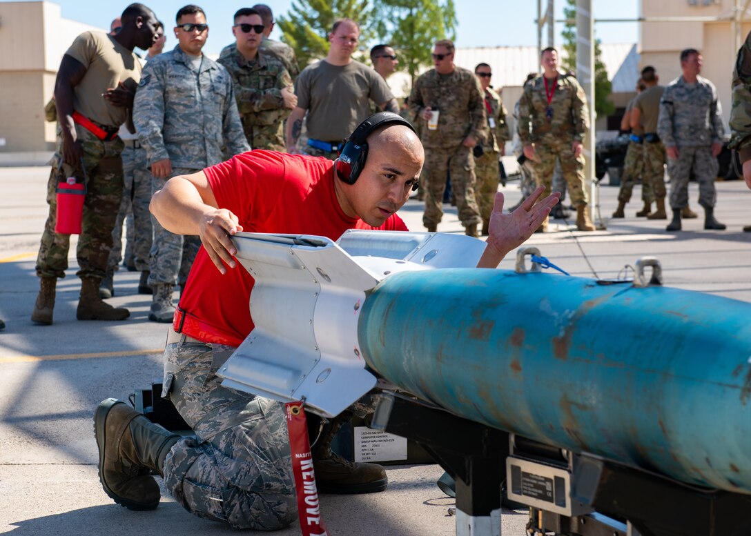 Staff Sgt. Kevin McCain, 63rd Aircraft Maintenance Unit load crew team chief, handles an inert bomb July 18, 2019, at Luke Air Force Base, Ariz.