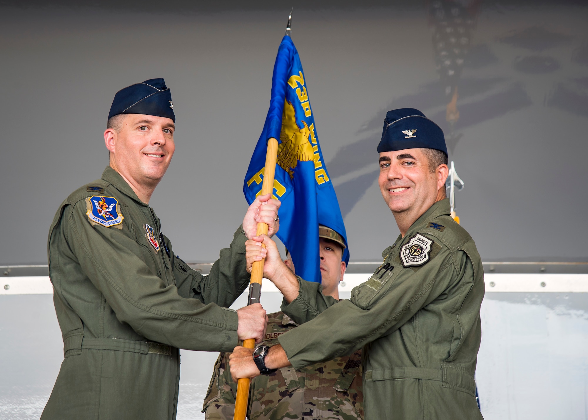 Col. Daniel Walls, left, 23d Wing Commander , receives the guidon from Col. Michael Curley, 23d Fighter Group (FG) commander, as he relinquishes command during the 23d FG change of command ceremony, July 19, 2019, at Moody Air Force Base, Ga. The ceremony is a military tradition that represents a formal transfer of unit’s authority and responsibility from one commander to another. Air Force’s largest A-10C Thunderbolt II fighter group that consists of two combat ready A-10C squadrons and an operation support squadron. Curley will be retiring today after more than 24 years of service to the nation and the Air Force. (U.S. Air Force photo by Airman 1st Class Eugene Oliver)