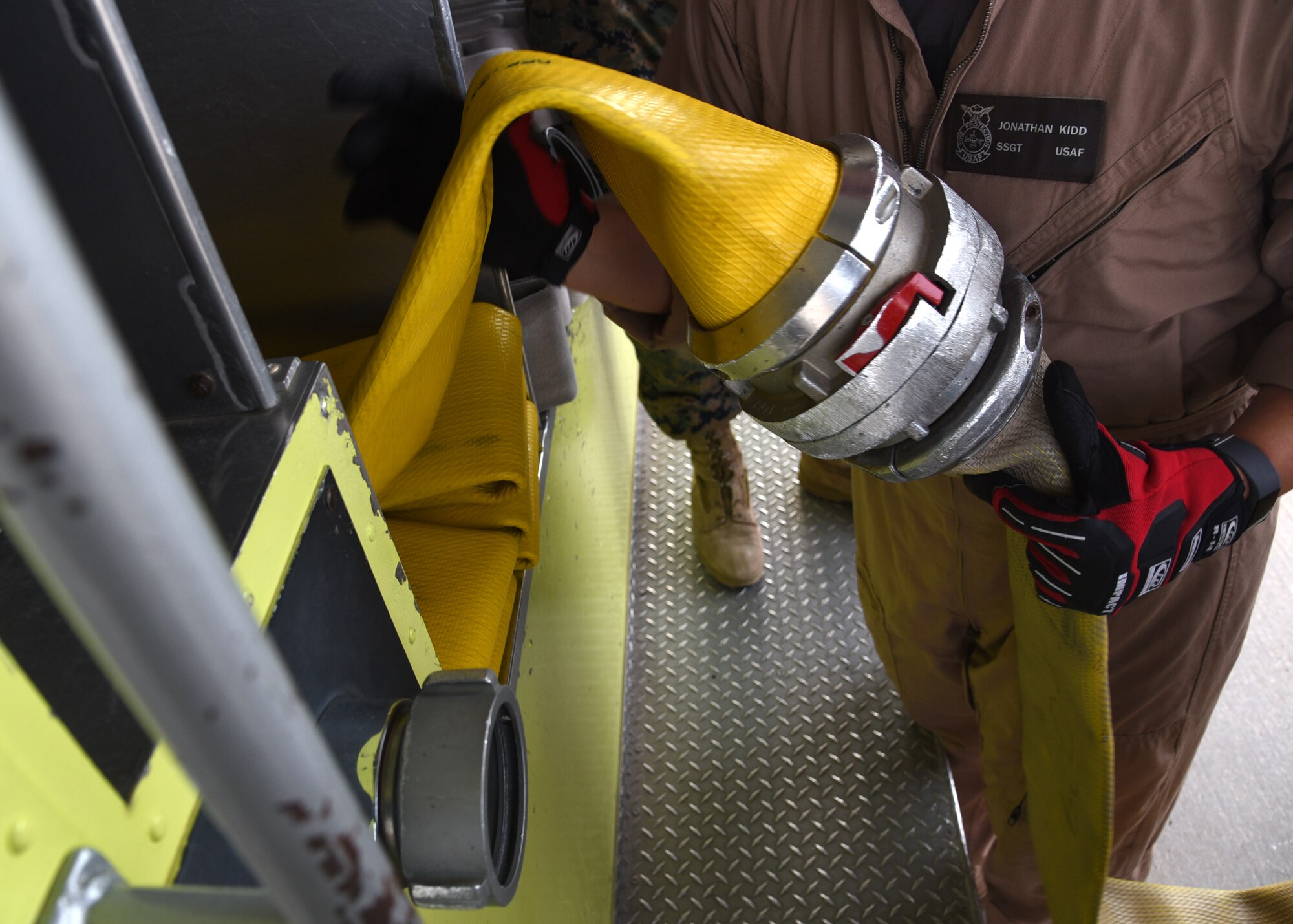 U.S. Air Force Staff Sgt. Jonathan Kidd, 312th Training Squadron instructor, demonstrates how to fold a fire hose coupling correctly into the back of a fire truck outside the Louis F. Garland Department of Defense Fire Academy on Goodfellow Air Force Base, Texas, July 11, 2019. Kidd emphasized that personal integrity is needed to store the fire hose not only correctly, but neatly and orderly as the hoses will be visible on the back of the fire truck by all of the base. (U.S. Air Force Photo by Airman 1st Class Abbey Rieves/Released)