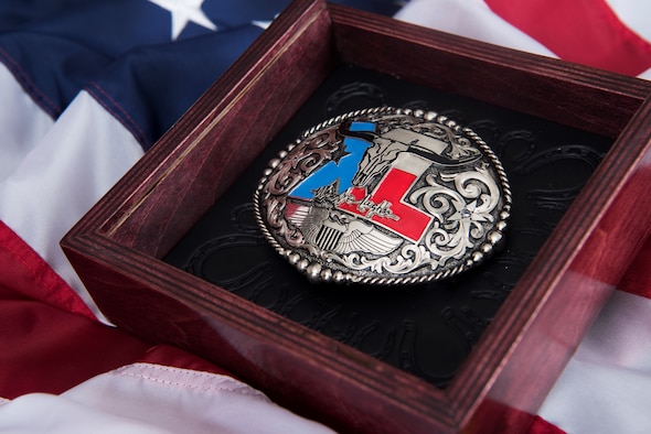 A custom belt buckle, designed for the wing’s newly inducted lifetime Honorary Commander lays in its shadow box at Laughlin Air Force Base, Texas, July 17, 2019. Nominations for this elite lifetime program, formally known as Laughlin’s Wings of Amistad, are not guaranteed during each commander’s tenure; however, each nominee exhibits a lifetime impact on this base community. (U.S. Air Force photo by Airman 1st Class Marco A. Gomez)