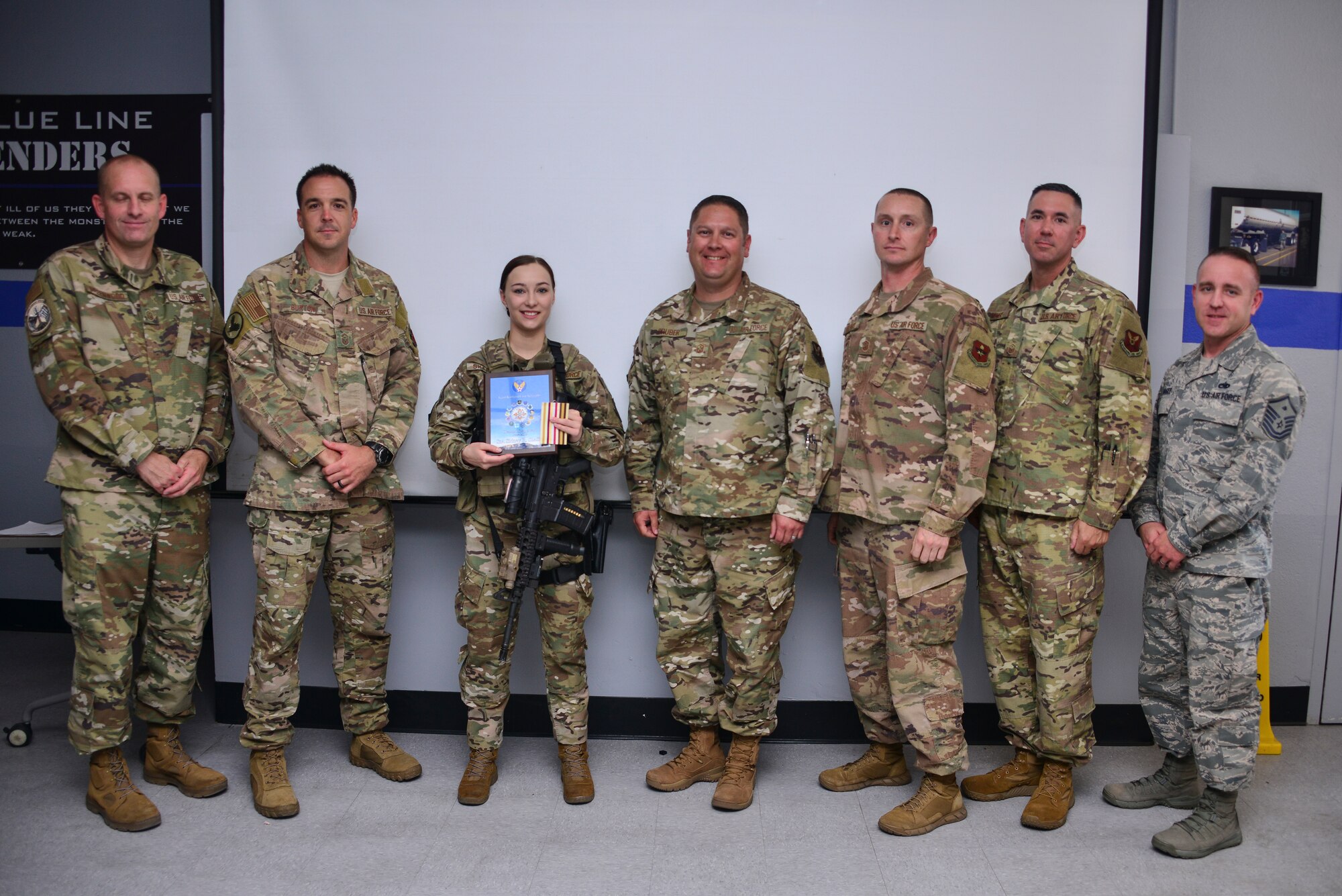 Center, U.S. Air Force Senior Airman Sidney Shaffer, 377th Security Forces Squadron base defense alarm monitor, receives the June Diamond Sharp Award from First Sergeant Council members.