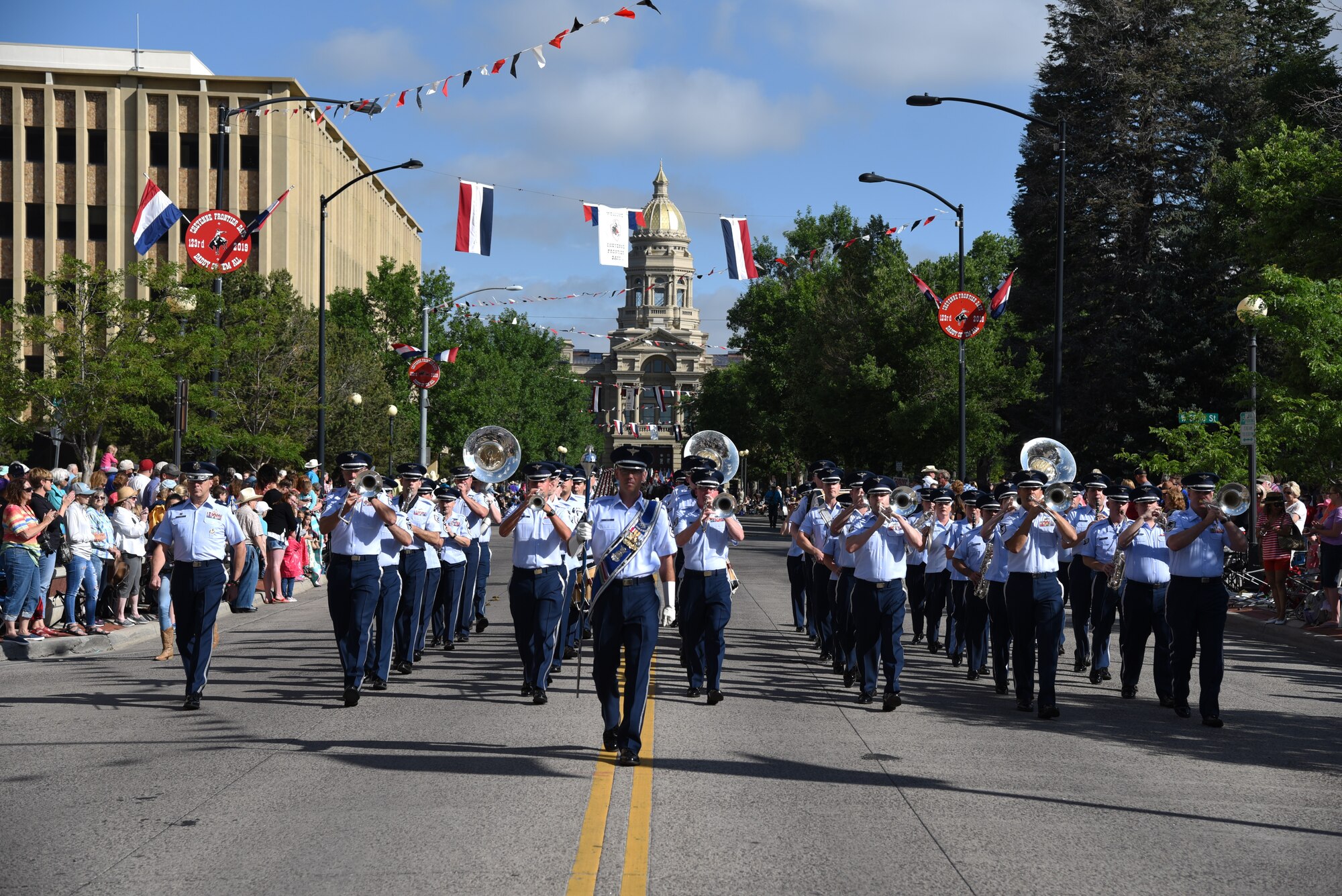 Members of the U.S. Air Force Academy Band play music as they march down the streets of Cheyenne, Wyo., during the 123rd Cheyenne Frontier Days opening Grand Parade, July 20, 2019. Airmen play many roles in making CFD, the biggest event in Cheyenne, a success. The two communities came together to celebrate during the CFD rodeo and festival. (U.S. Air Force photo by Glenn S. Robertson)