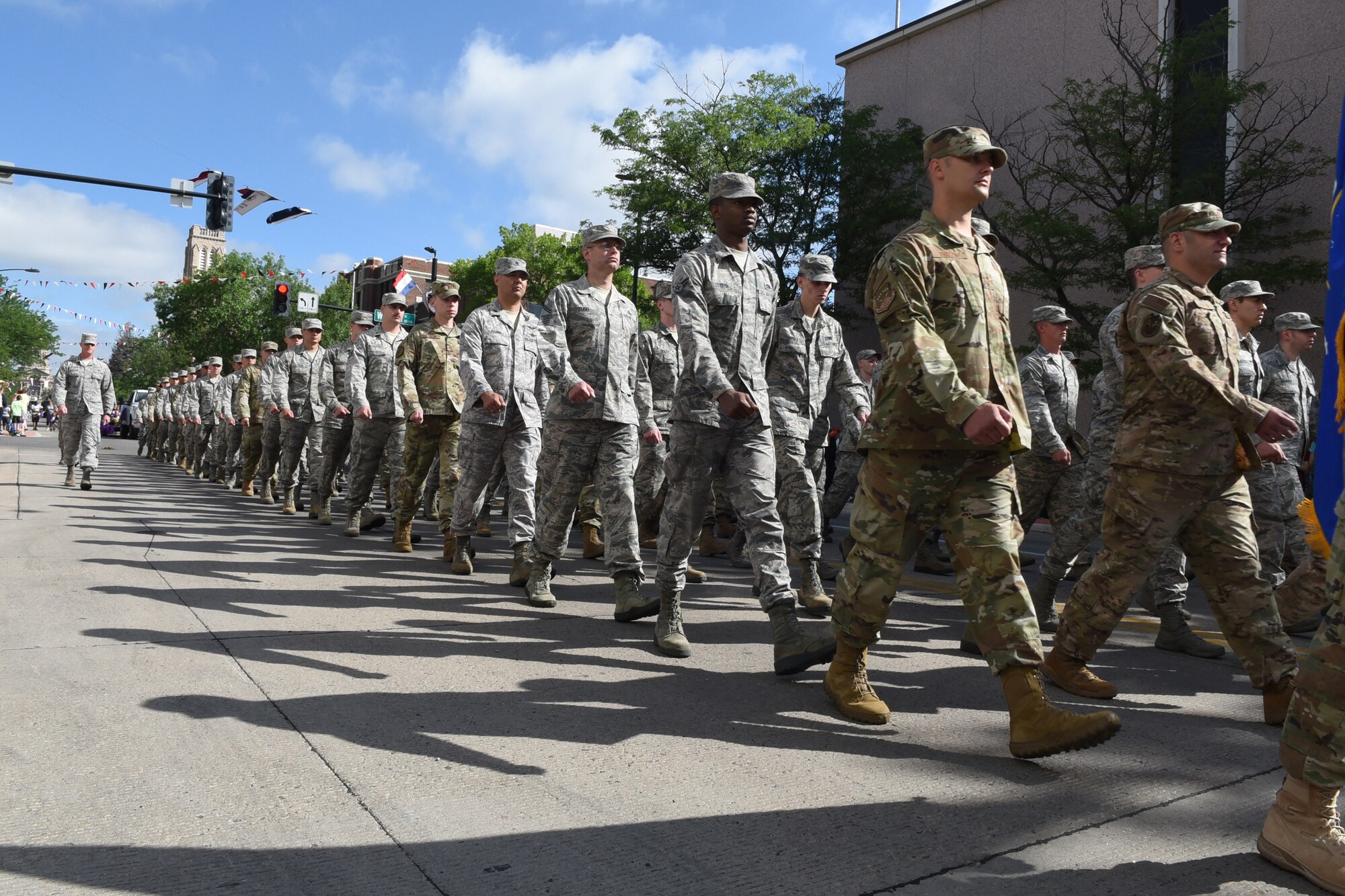 Airmen from F.E. Warren Air Force Base, Wyo., march in formation during the 123rd Cheyenne Frontier Days opening Grand Parade in Cheyenne, Wyo., July 21, 2018. Service members from multiple branches took part in the parade, as well as a number of civic and veteran service organizations. This year marks the 152nd anniversary of F.E. Warren Air Force Base and the city of Cheyenne. The F.E. Warren Air Force Base and Cheyenne communities came together to celebrate the CFD rodeo and festival, which runs from July 20-29. (U.S. Air Force photo illustration by Senior Airman Breanna Carter)