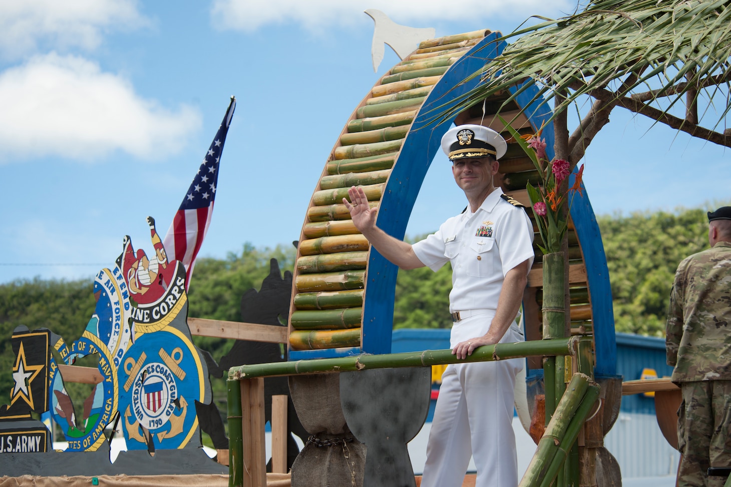 190721-N-AY639-0009 AGANA, Guam (July 21, 2019) Cmdr. David Cox, deputy commander of Commander, Submarine Squadron Fifteen, waves to parade attendees from the Inarajan village float during the annual Guam Liberation Day Parade, July 21. The celebration commemorates the 75th anniversary of the liberation of Guam from Japanese occupation by U.S. forces during World War II.