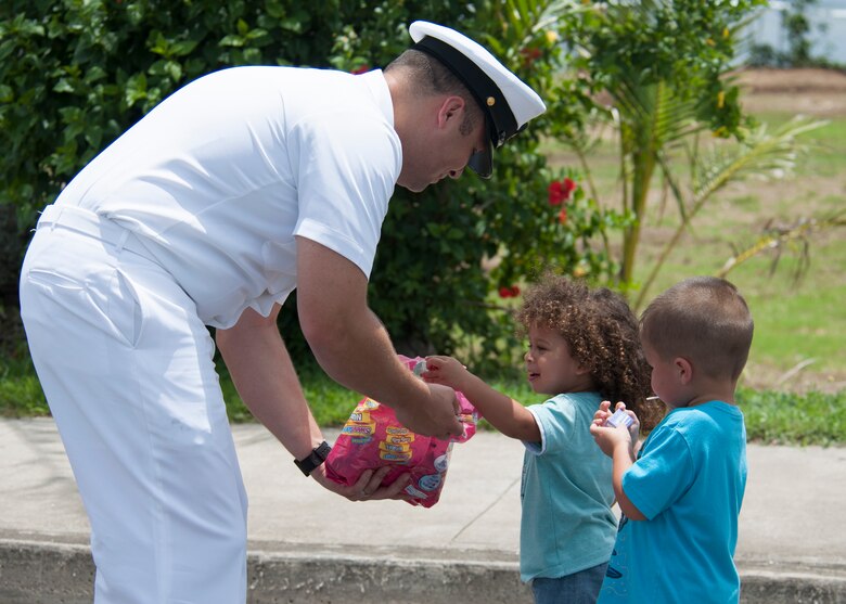 190721-N-AY639-0011 AGANA, Guam (July 21, 2019) Chief Hospital Corpsman Cody Werven, a native of Cavalier, North Dakota, hands out candy to children during the annual Guam Liberation Day Parade, July 21. The celebration commemorates the 75th anniversary of the liberation of Guam from Japanese occupation by U.S. forces during World War II.