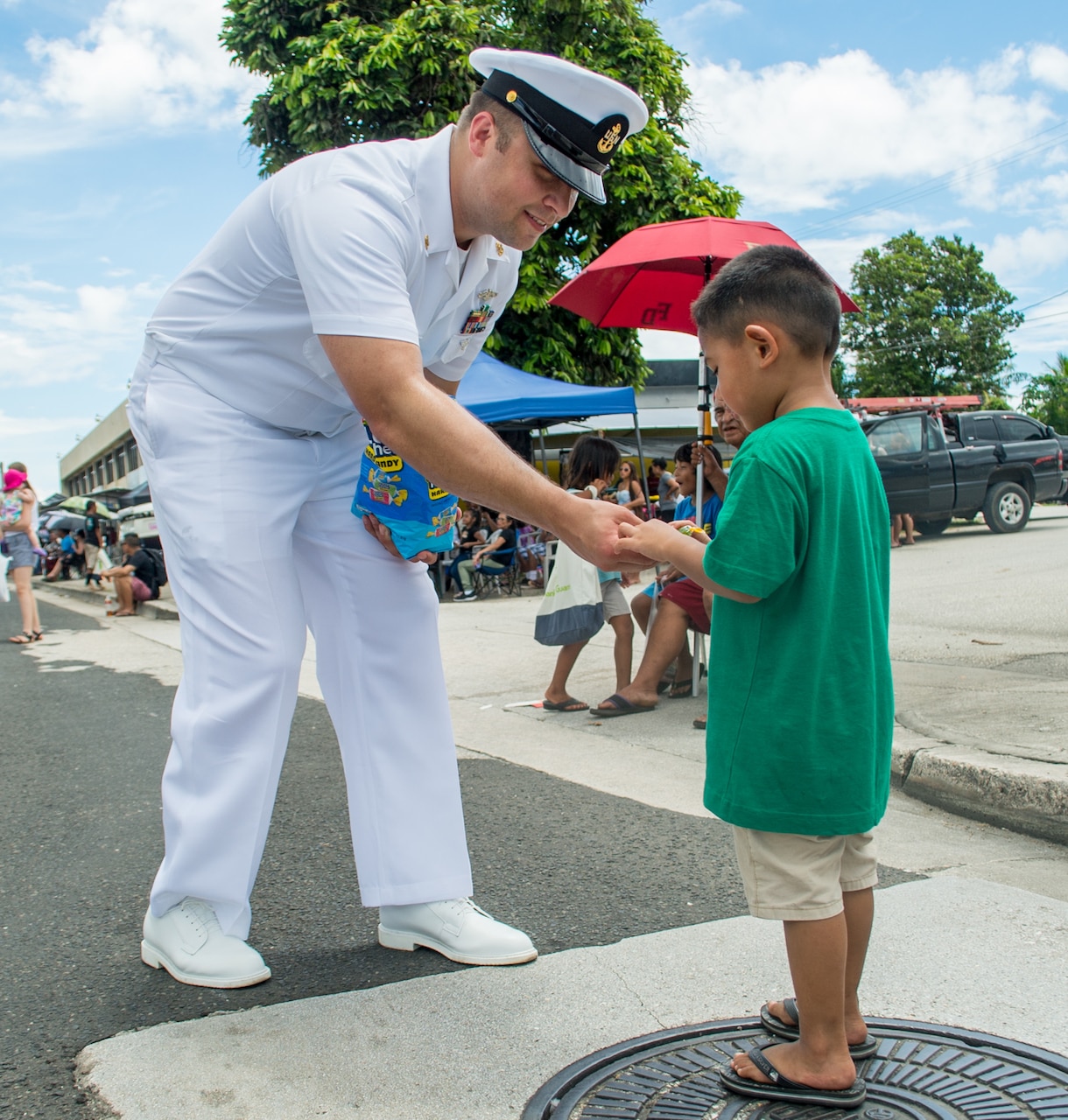 AGANA, Guam (July 21, 2019) Chief Hospital Corpsman Cody Werven, assigned to Commander, Submarine Squadron Fifteen, a native of Cavalier, North Dakota, hands out candy to children during the annual Liberation Day parade. The celebration commemorates the 75th anniversary of the liberation of Guam from Japanese occupation by U.S. forces during World War II.
