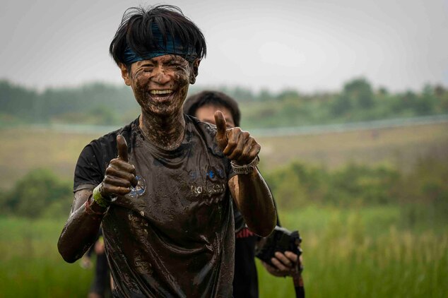 泥まみれになりながらもコースを完走した日本人参加者。キャンプ富士で７月21日、約400人の地元及び米軍関係者が参加した約６キロの障害物レースが開催され、それぞれが楽しみながらコースを完走していました。