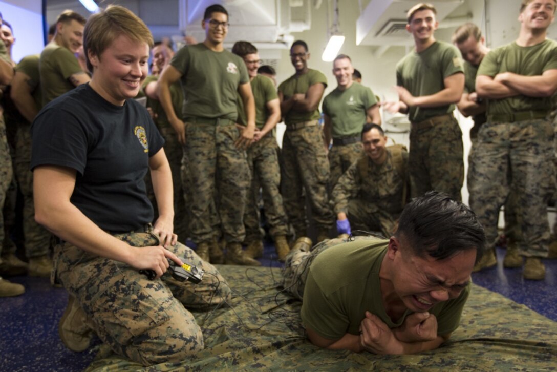 Sgt. Arielle Lahtinen, noncommissioned officer in charge with the 31st MEU's Law Enforcement detachment, tases a Marine with a Conducted Energy Weapon, or TASER, during a non-lethal weapons course aboard the amphibious assault ship USS Wasp (LHD 1), underway in the Coral Sea, June 30, 2019. (Official Marine Corps photo by Lance Cpl. Cameron Parks)