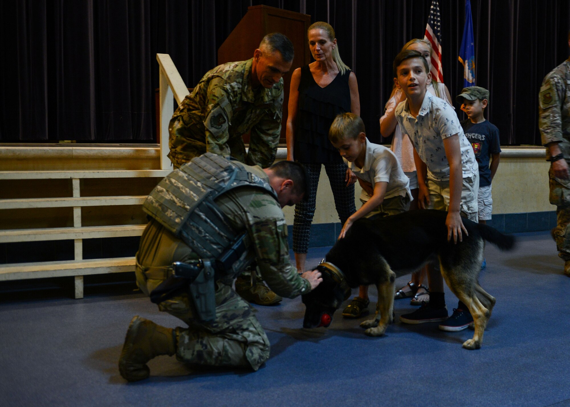 U.S. Air Force Staff Sgt. Shane Massie, 31st Security Forces Squadron military working dog handler, and the Lasica family greet MWD Cigan after a retirement ceremony at Aviano Air Base, Italy, July 19, 2019. Massie was MWD Cigan's most recent handler but will be passing on Cigan into the care of Brig. Gen. Daniel T. Lasica and his family. (U.S. Air Force photo by Staff Sgt. Rebeccah Woodrow)