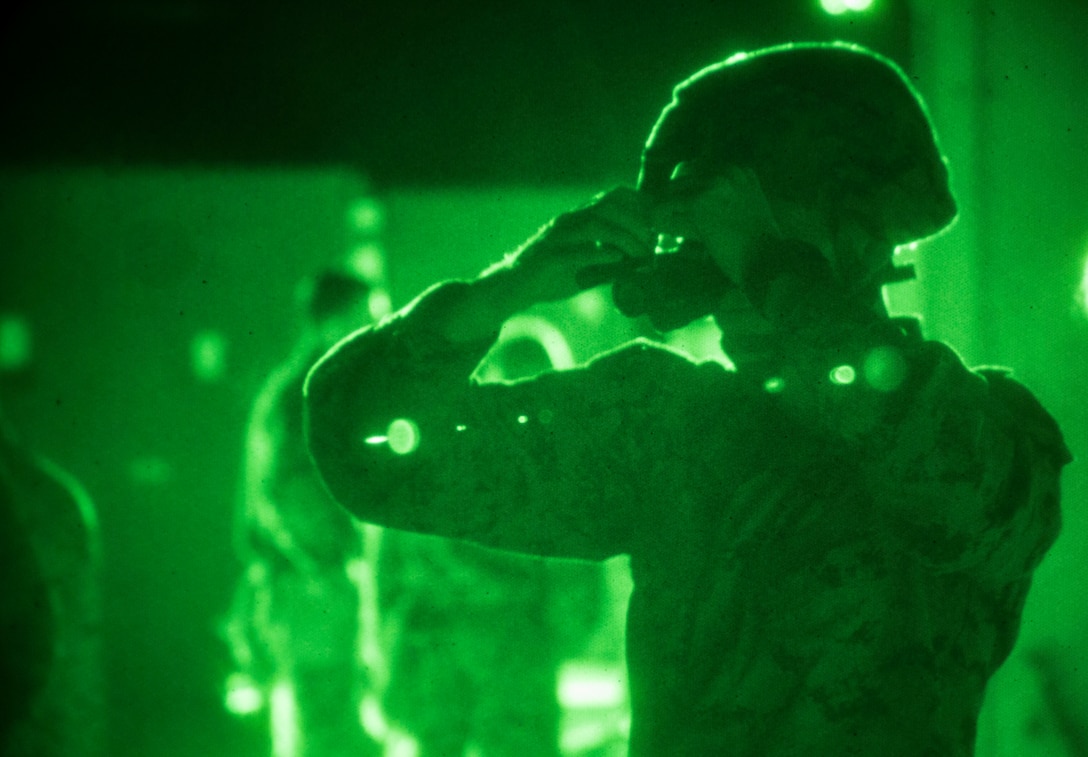 A U.S. Marine with Special Purpose Marine Air-Ground Task Force-Crisis Response-Africa 19.2, Marine Forces Europe and Africa, prepares his night-vision goggle for a tactical recovery of aircraft and personnel mission rehearsal on Moron Air Base, Spain, July 4 , 2019. The rehearsal was conducted to maintain high-response time and proficiency in night operations as a crisis-response force. SPMAGTF-CR-AF is deployed to conduct crisis-response and theater-security operations in Africa and promote regional stability by conducting military-to-military training exercises throughout Europe and Africa. (U.S. Marine Corps photo by Cpl. Margaret Gale)