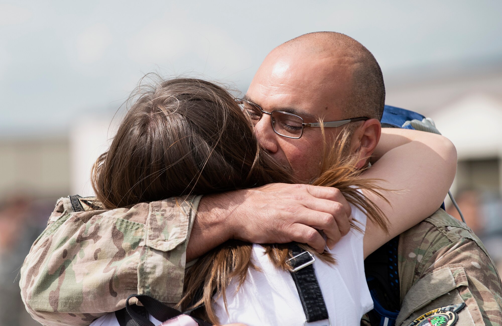 A U.S. Air Force member from the 48th Fighter Wing reunites with his family at Royal Air Force Lakenheath, England, July 12, 2019. Members of the 493rd Fighter Squadron and 748th Aircraft Maintenance Squadron were deployed to an undisclosed location for six months. (U.S. Air Force photo by Senior Airman Malcolm Mayfield)