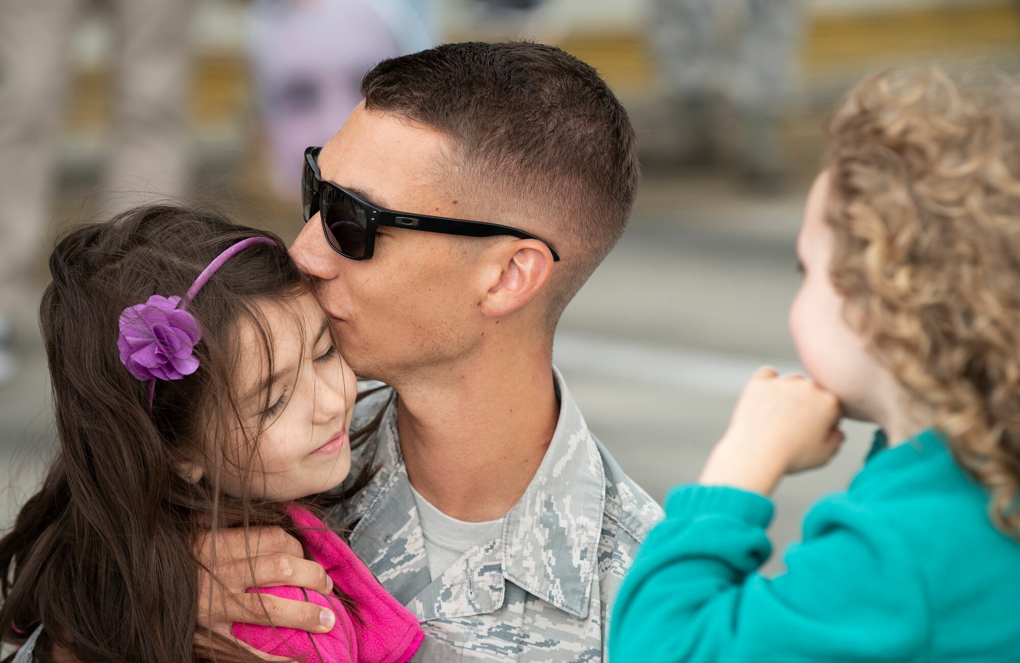 A U.S. Air Force member from the 48th Fighter Wing reunites with his family at Royal Air Force Lakenheath, England, July 12, 2019. Members of the 493rd Fighter Squadron and 748th Aircraft Maintenance Squadron were deployed to an undisclosed location for six months. (U.S. Air Force photo by Senior Airman Malcolm Mayfield)