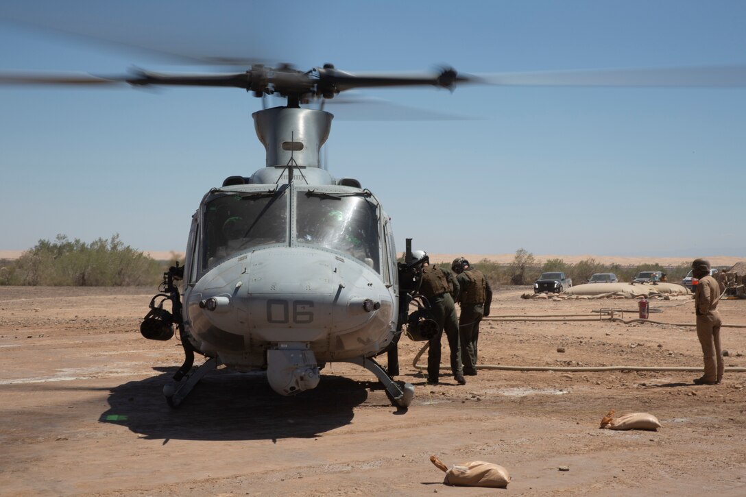 U.S. Marines with Marine Light Attack Helicopter Squadron (HMLA) 267, Marine Aircraft Group (MAG) 39, 3rd Marine Aircraft Wing (MAW), refuel a UH-1Y Venom at a forward arming refueling point during Exercise Summer Fury 19 in El Centro, Calif., July 15, 2019. Summer Fury 19 is designed to enhance Marine Air-Ground Task Force integration and increase aviation operations proficiency within the 3rd MAW and its adjacent units. (U.S. Marine Corps photo by Sgt. Charles Plouffe)