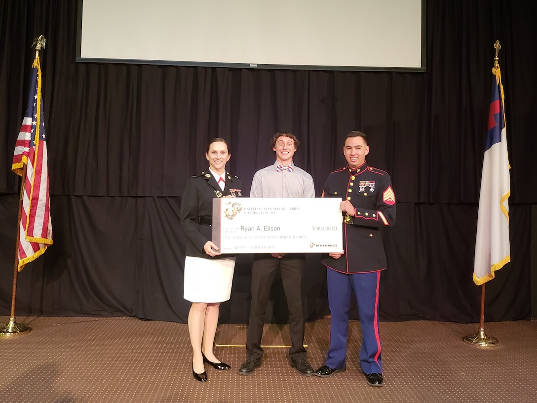 U.S. Marine Capt. Rachel Baker and Sgt. Brandon Dacier present Ryan Elison with his NROTC scholarship check. Elison was one of eight students from Recruiting Station Sacramento to be selected to receive the scholarship.