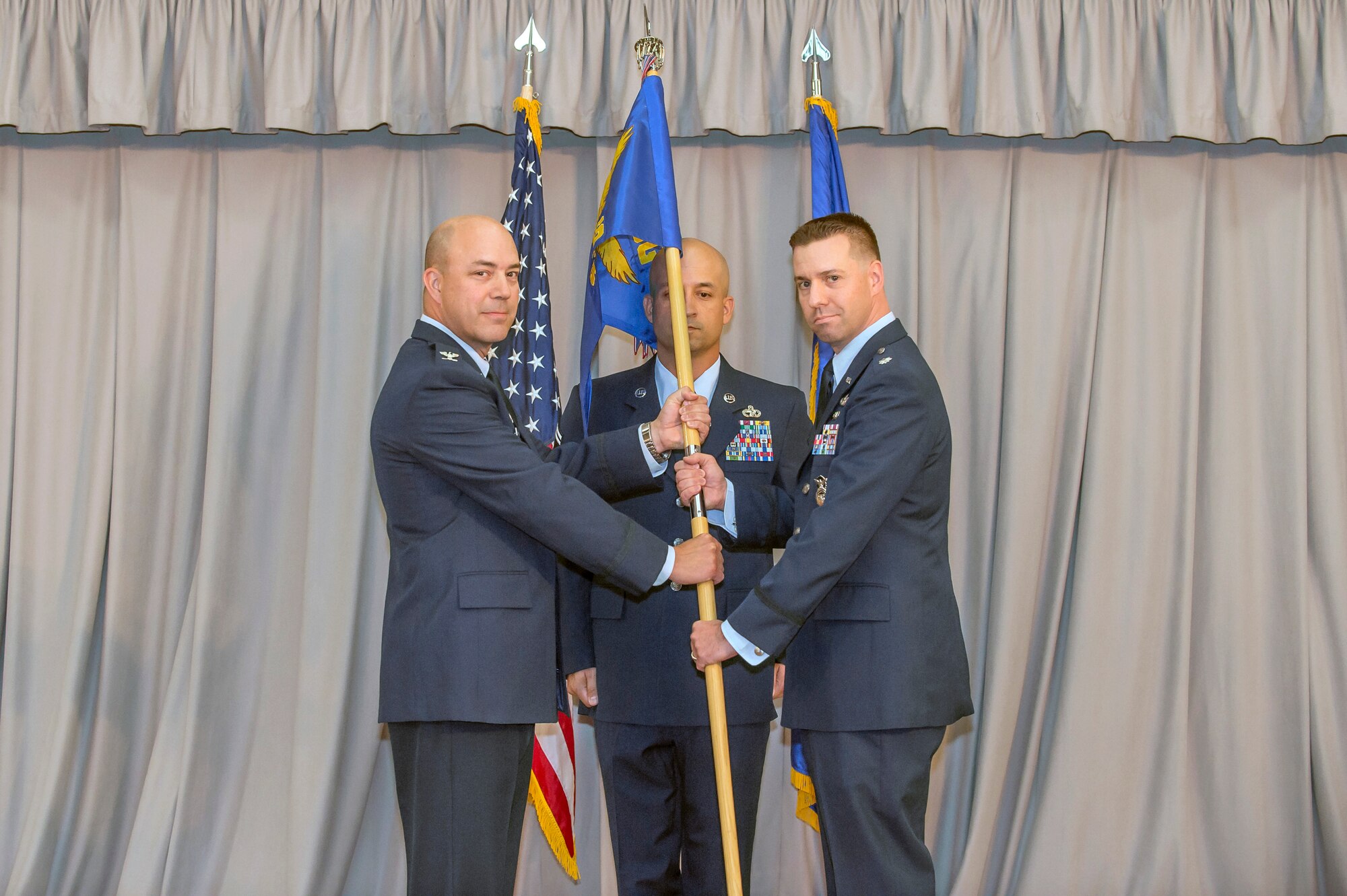 Col. Jeffry Hollman, 412th Mission Support Group commander (left), and new 412th Security Forces Squadron commander, Lt. Col. Joseph Bincarousky, Sr., pose with the squadron’s guidon during an assumption of command ceremony in Club Muroc July 19.  (U.S. Air Force photo by Richard Gonzales)