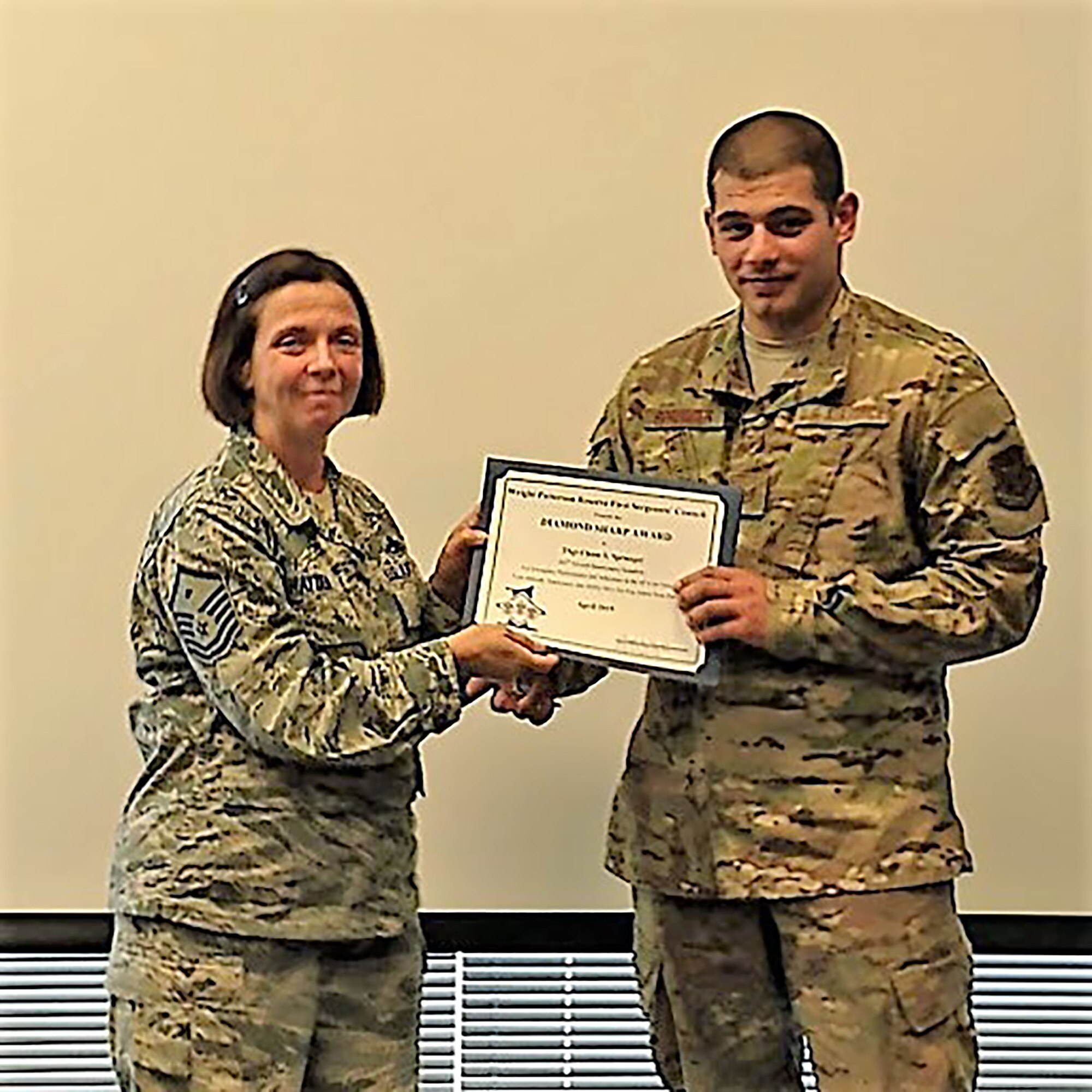 Master Sgt. Angela Hayden, 14th Intelligence Squadron first sergeant, presents the April 2019 Diamond Sharp Award to Tech. Sgt. Chase Sprunger, 445th Aircraft Maintenance Squadron, aircraft maintenance craftsman, during the July 2019 unit training assembly. The award is for exemplary performance, adherence to the Air Force Core Values, attitude, appearance and ability.