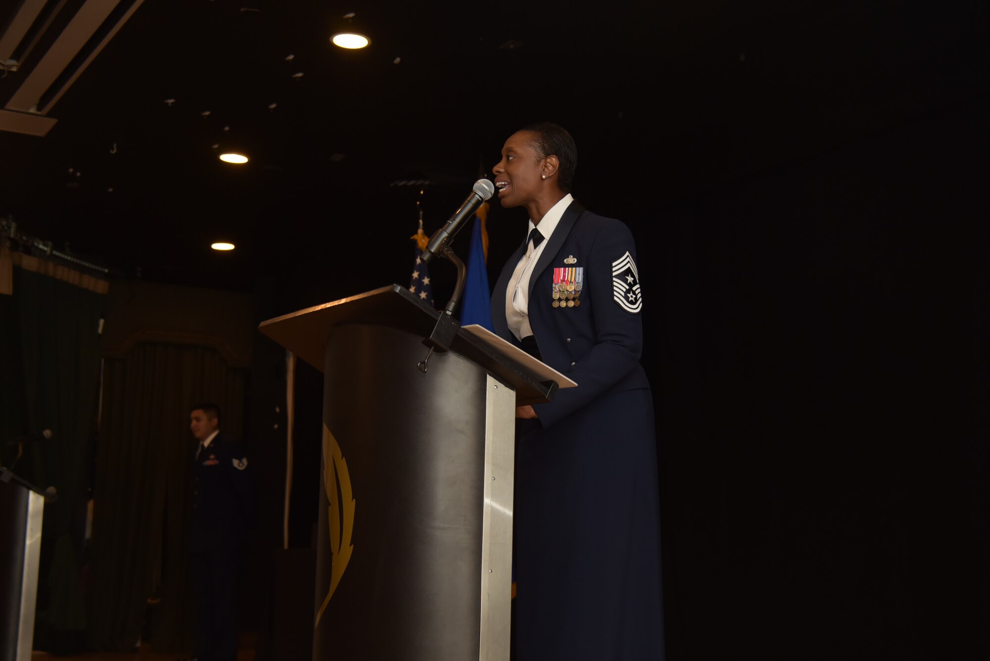 U.S. Air Force Chief Master Sgt. Tamar Dennis, 460th Space Wing command chief, speaks to Airmen during the Senior Non-commissioned Officers Induction Ceremony at Heritage Eagle Bend Golf Club in Aurora, Colo., July 19, 2019. There ceremony formally honored NCOs who were selected to move into the top enlisted tier of the Air Force as master sergeants.